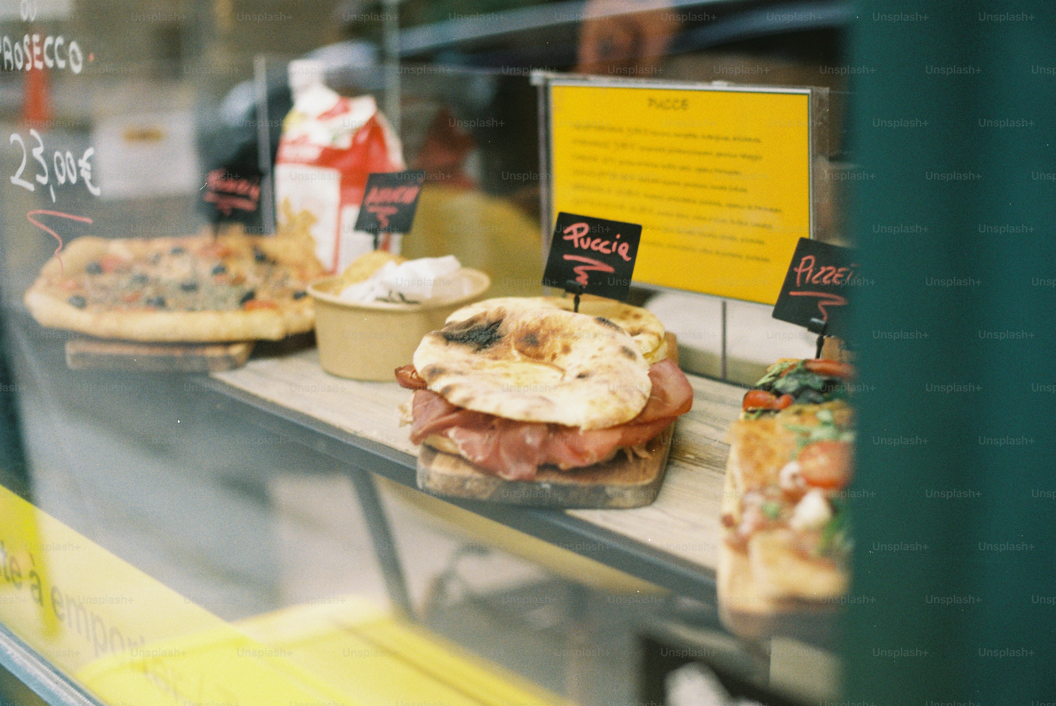 Panini e dolci esposti nella vetrina di un banco di cibo.