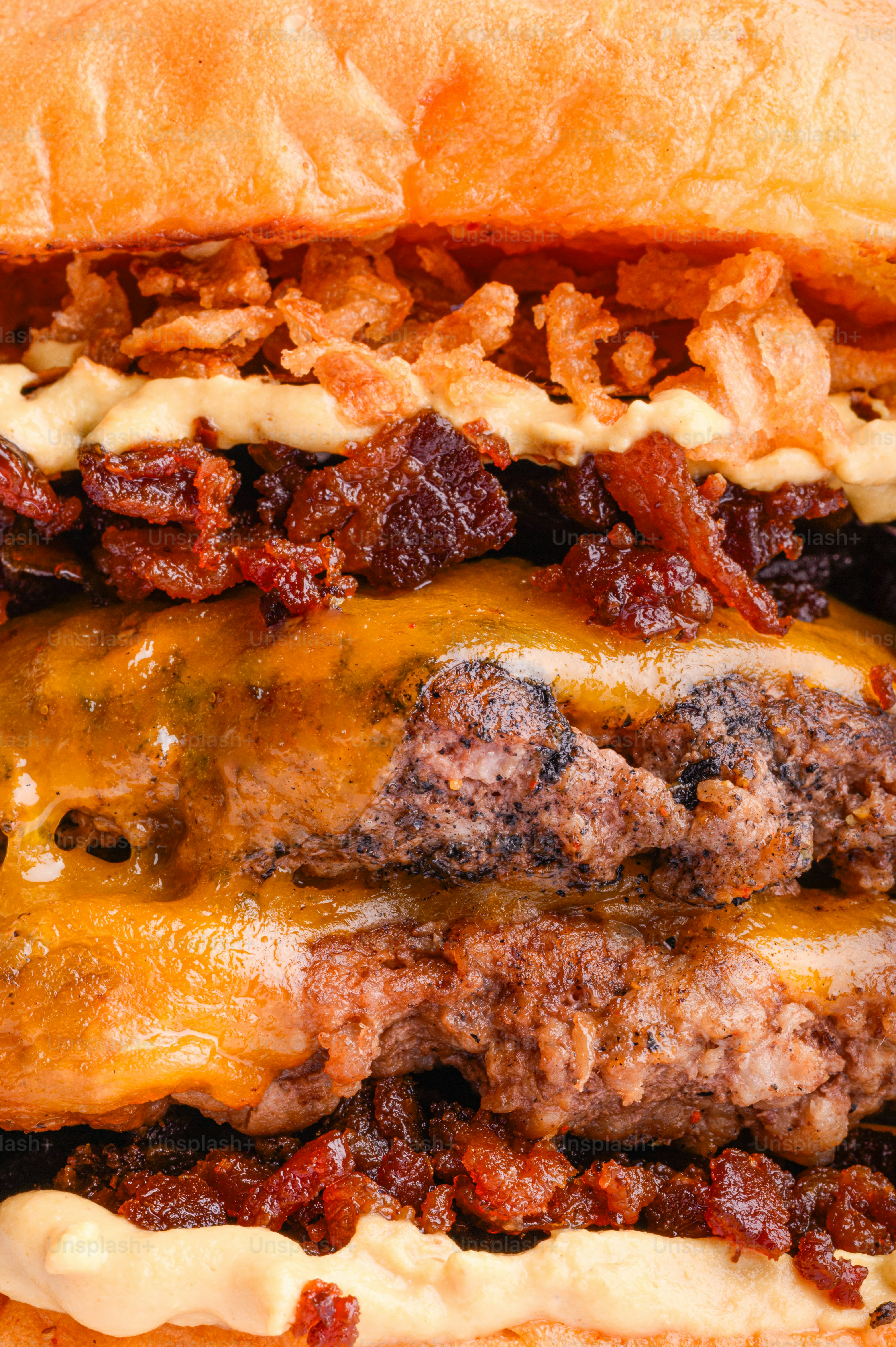 A close-up of a delicious double cheeseburger with crispy onions.