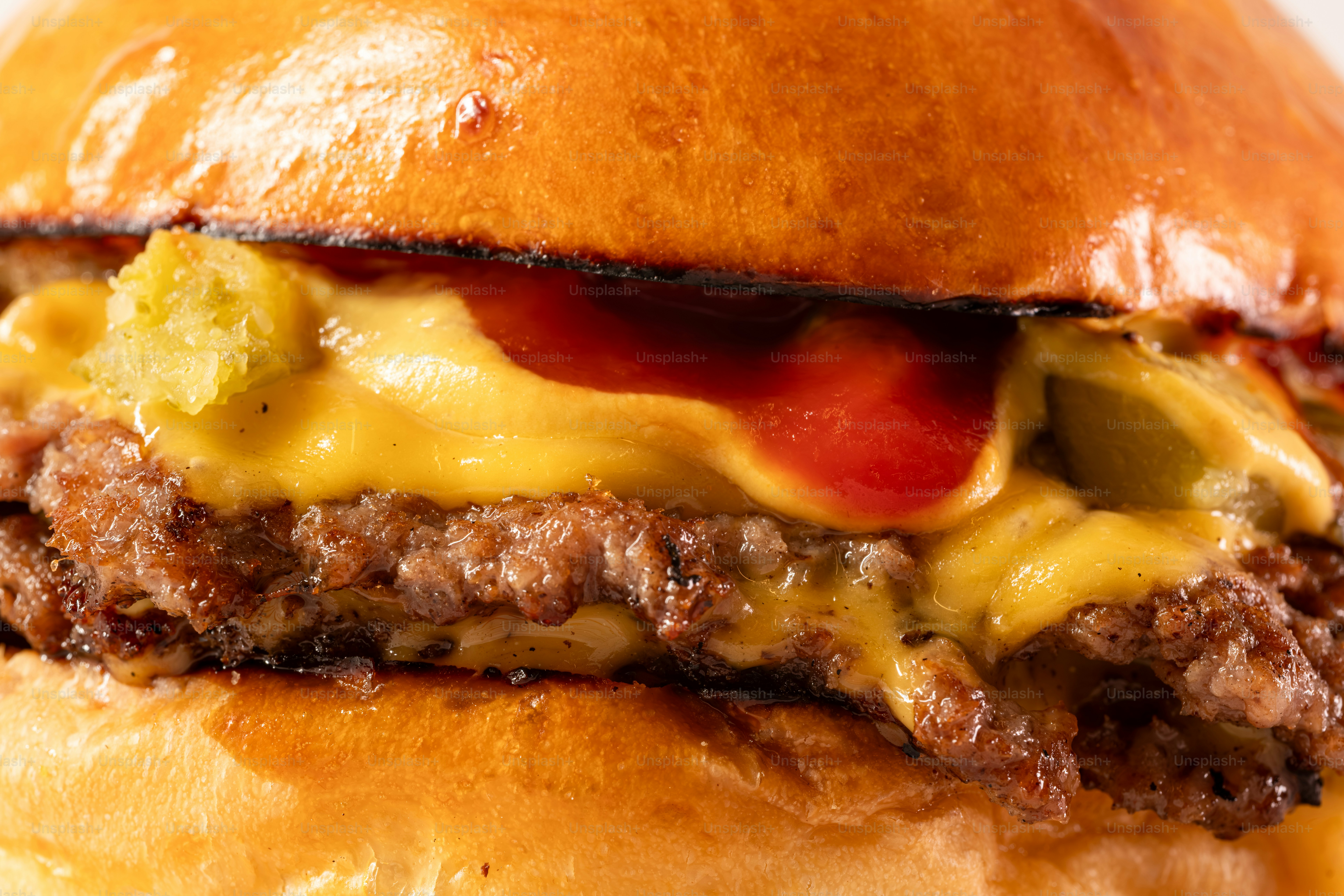 Um close de um cheeseburger suculento com queijo derretido.