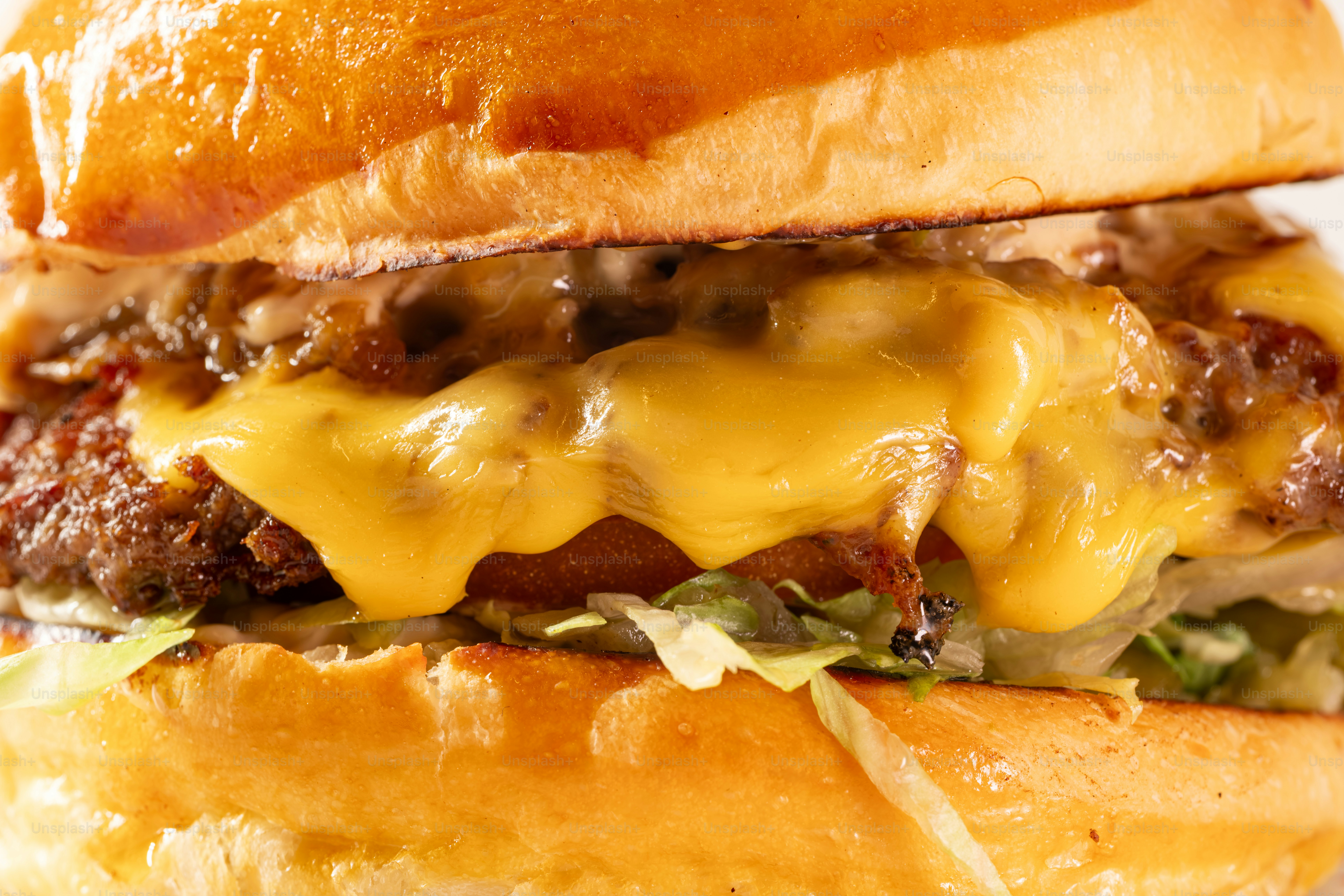 Um close de um cheeseburger suculento com queijo derretido.
