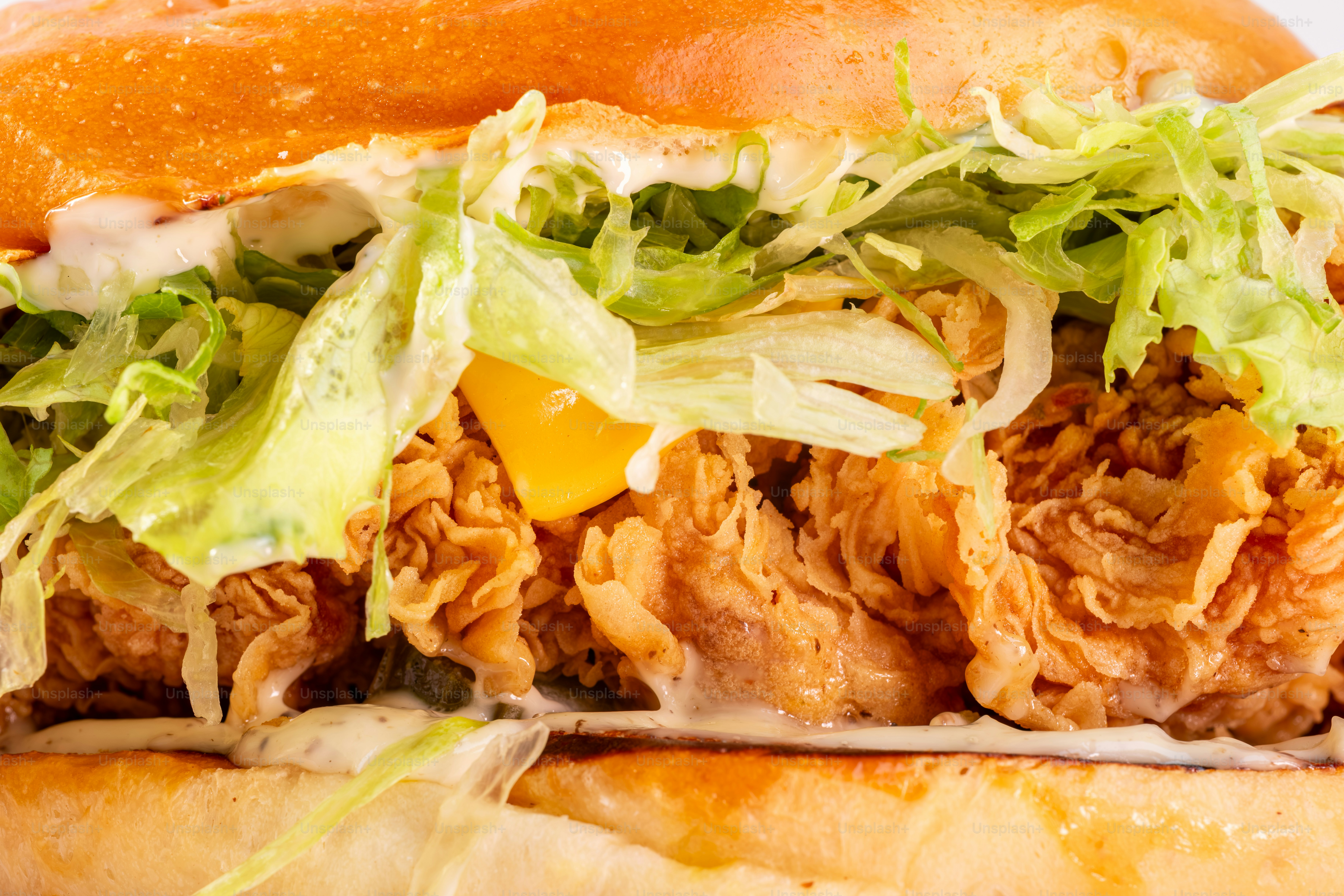 Sanduíche de frango frito crocante com alface e queijo