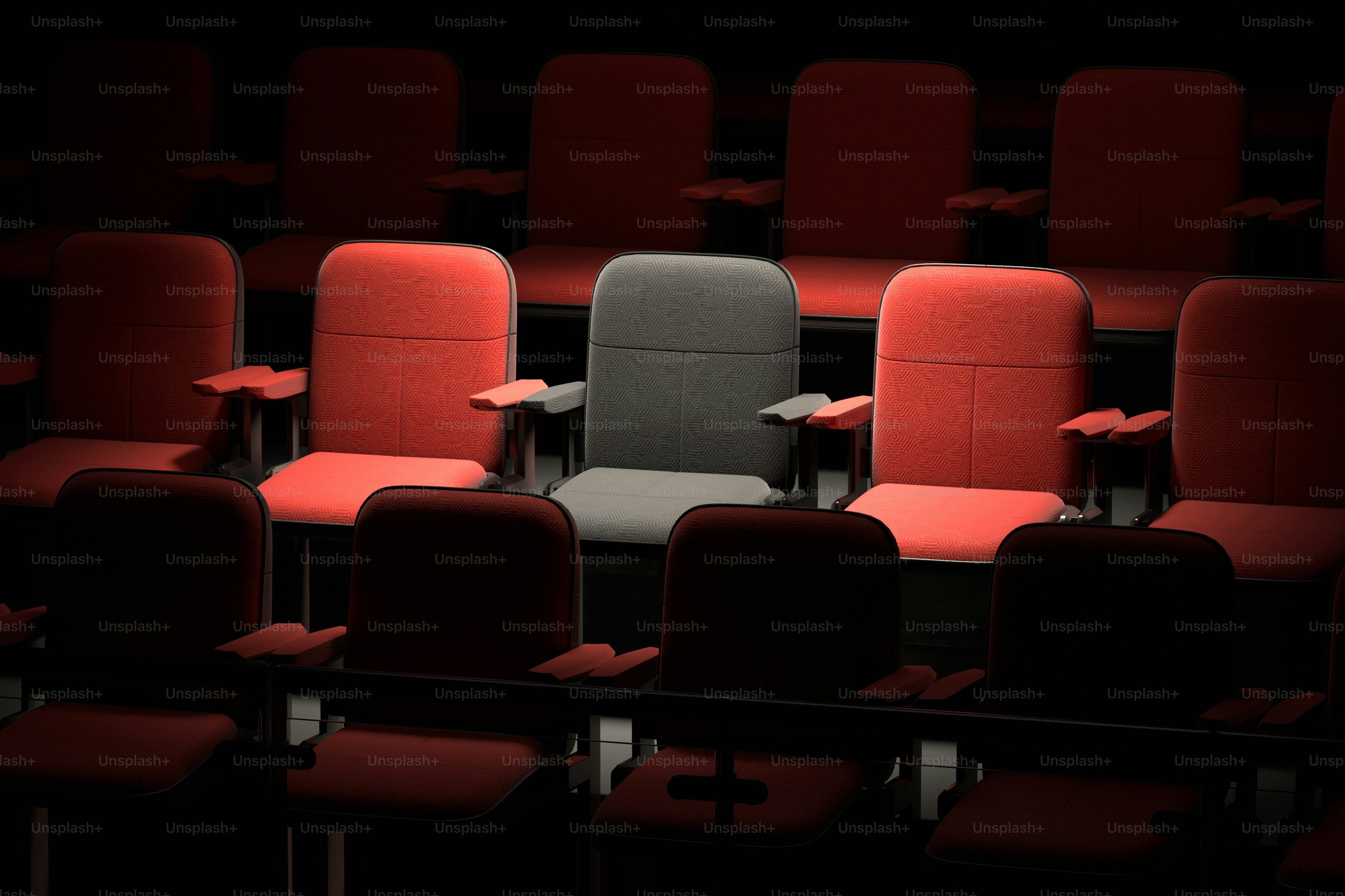 Satu kursi abu-abu menonjol di antara kursi merah.