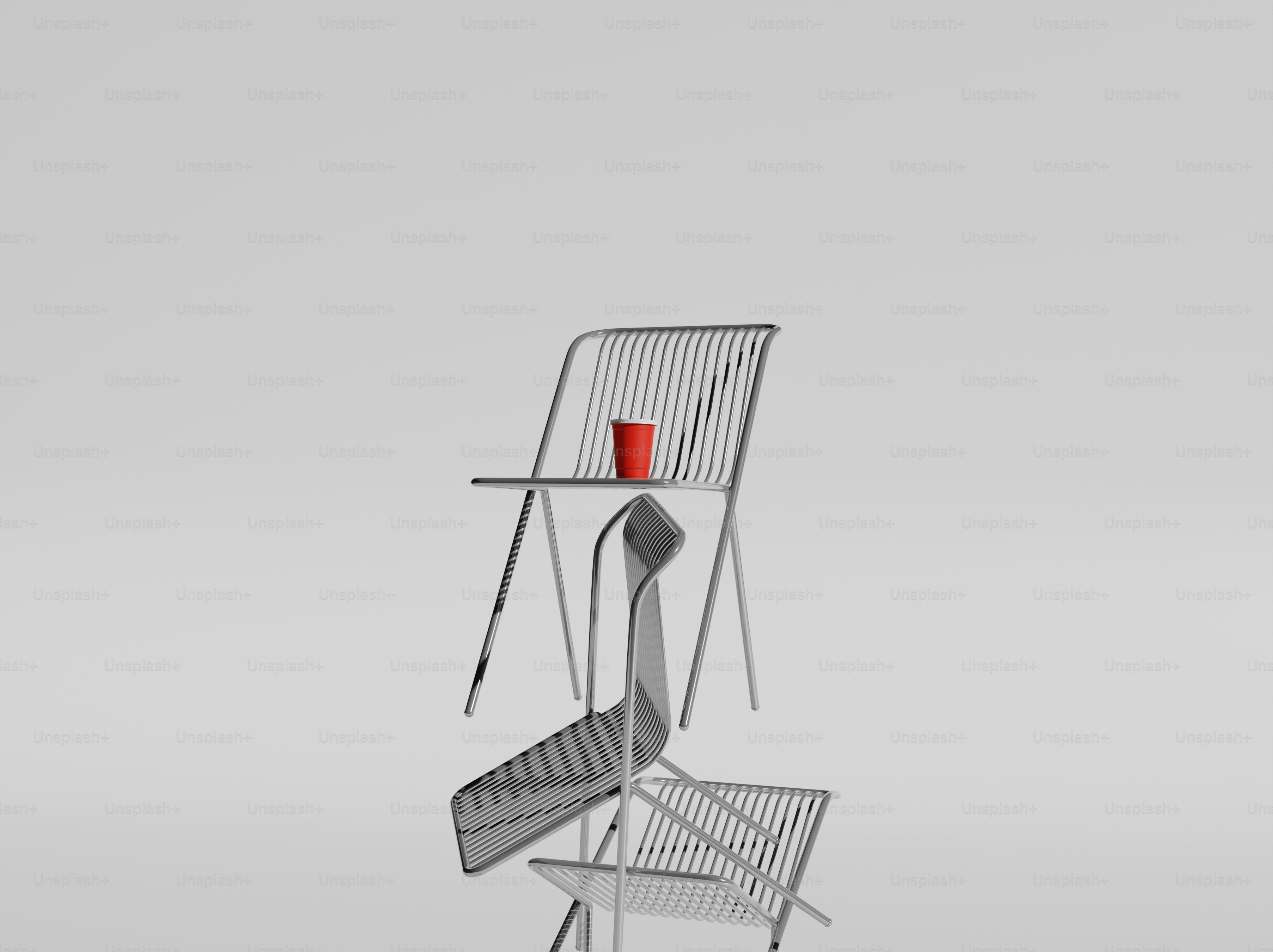 Une tasse rouge repose sur une pile de chaises.