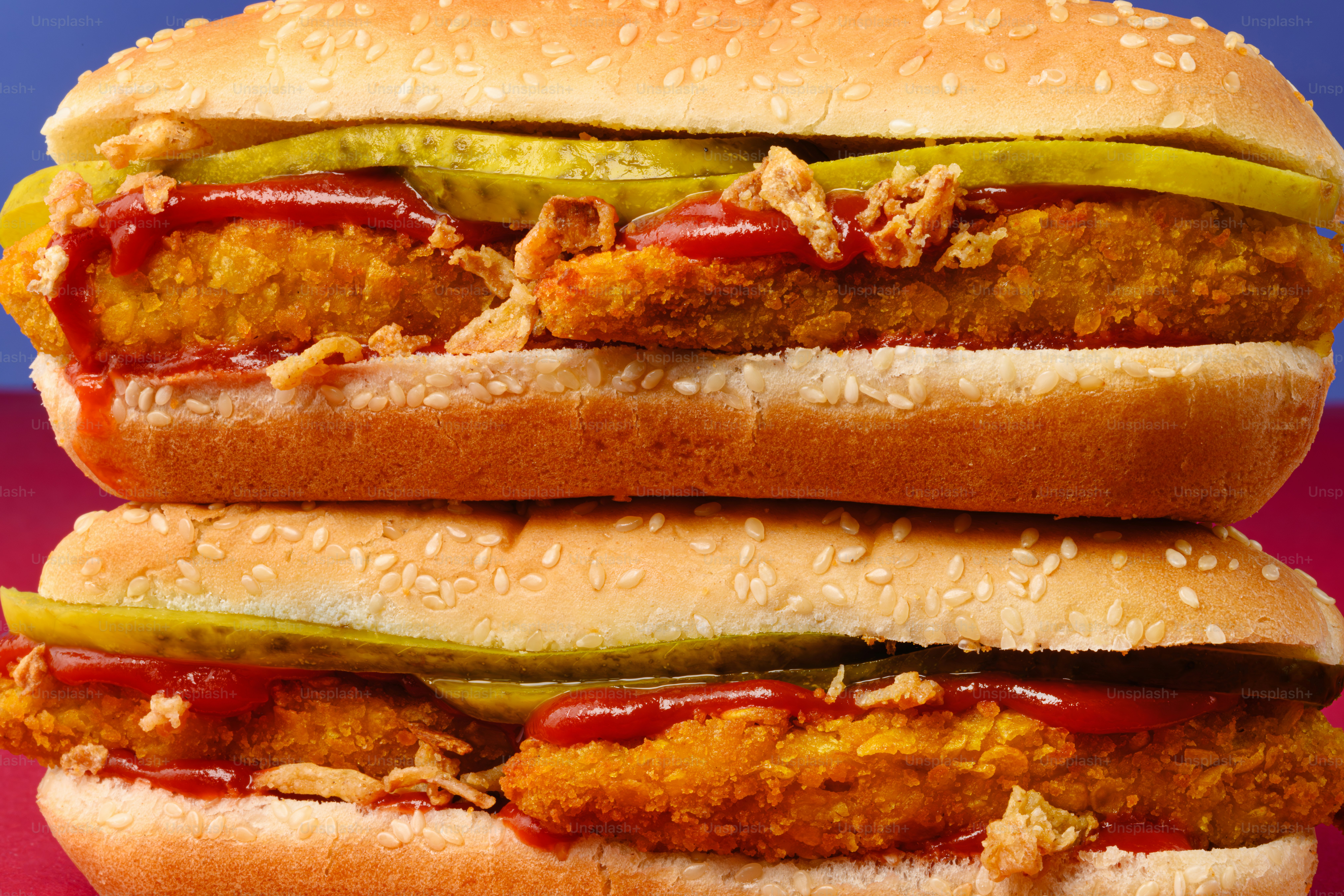 Due hamburger di pollo impilati con cetrioli e ketchup