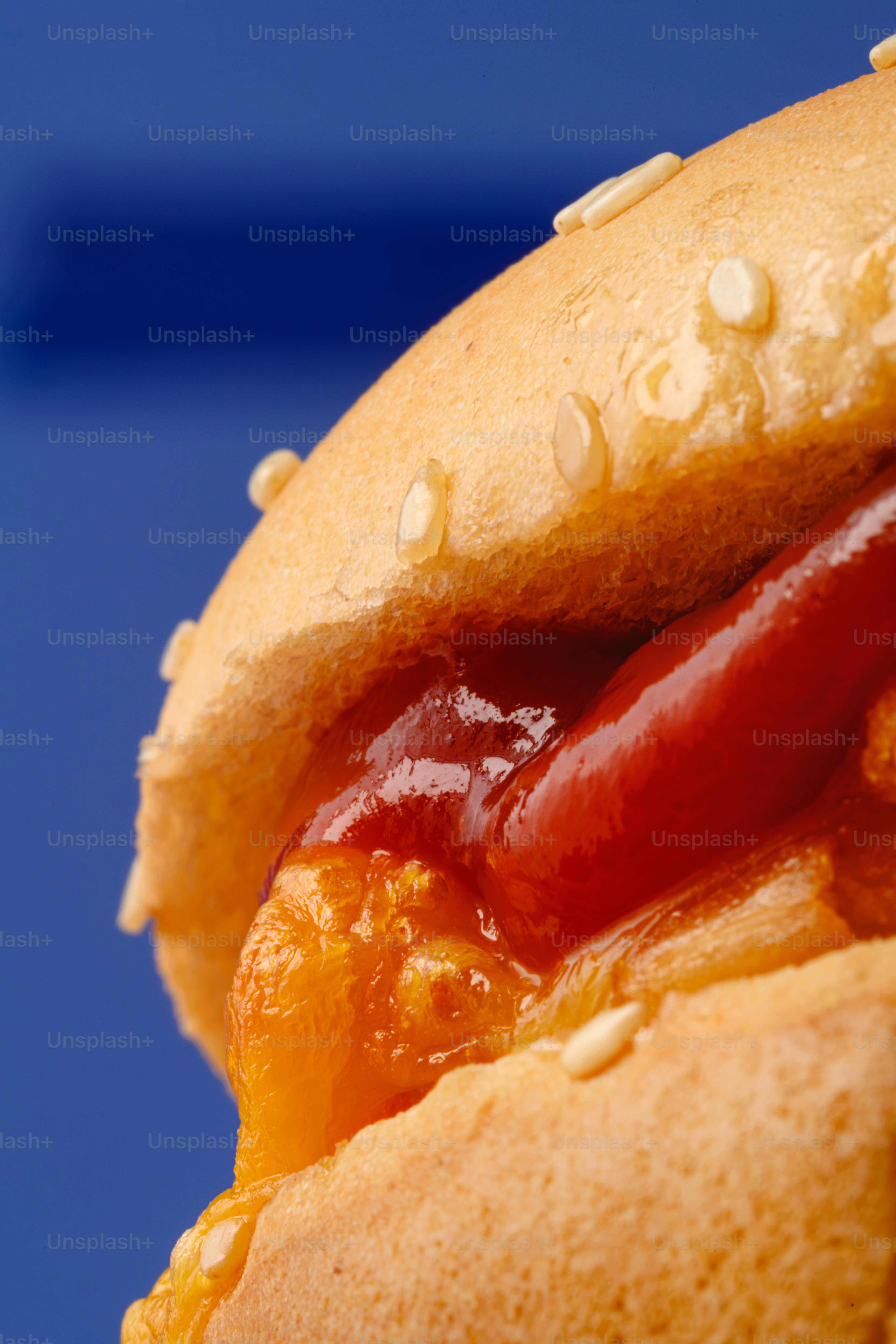 Primo piano di un hot dog con ketchup e formaggio.