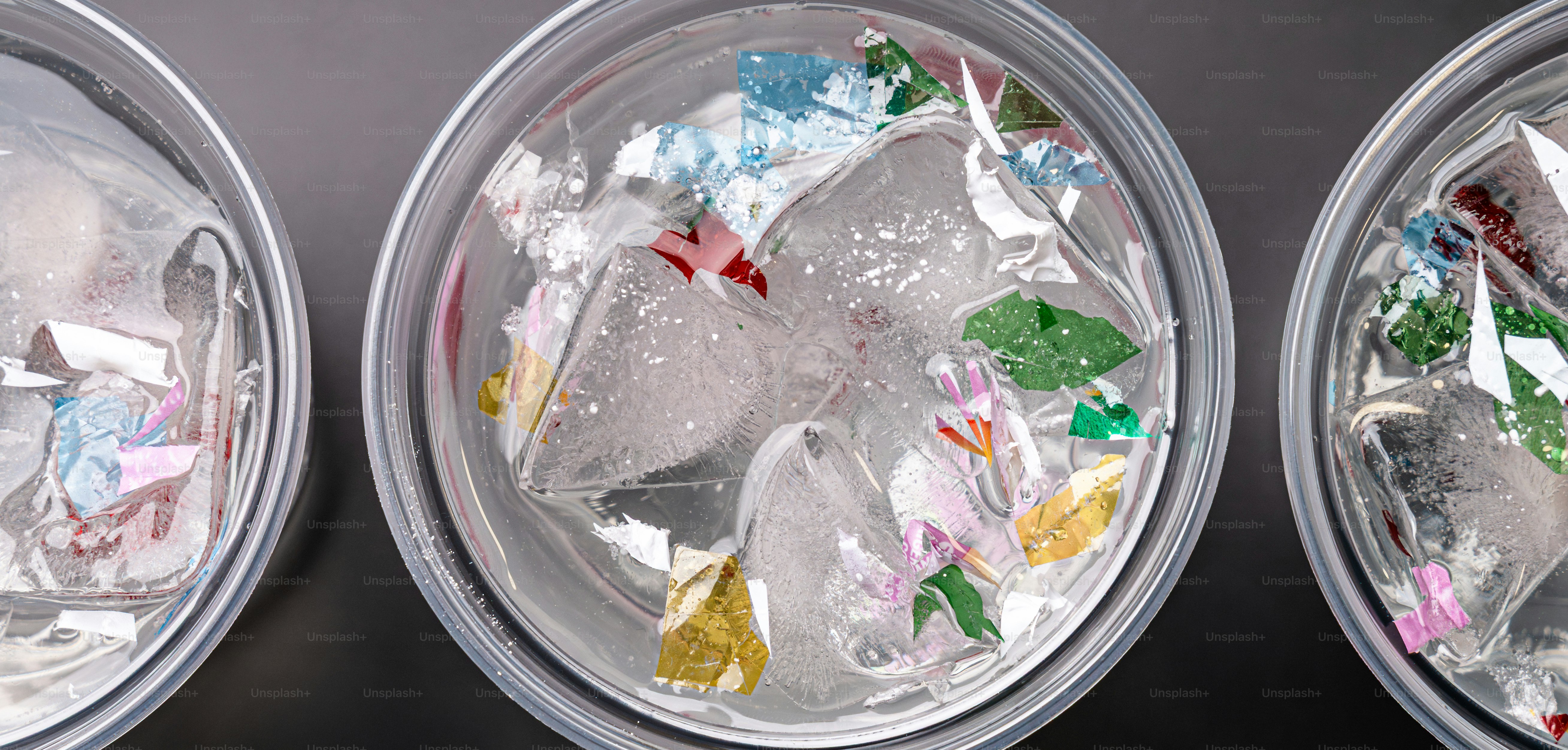 Three containers with colorful confetti inside.