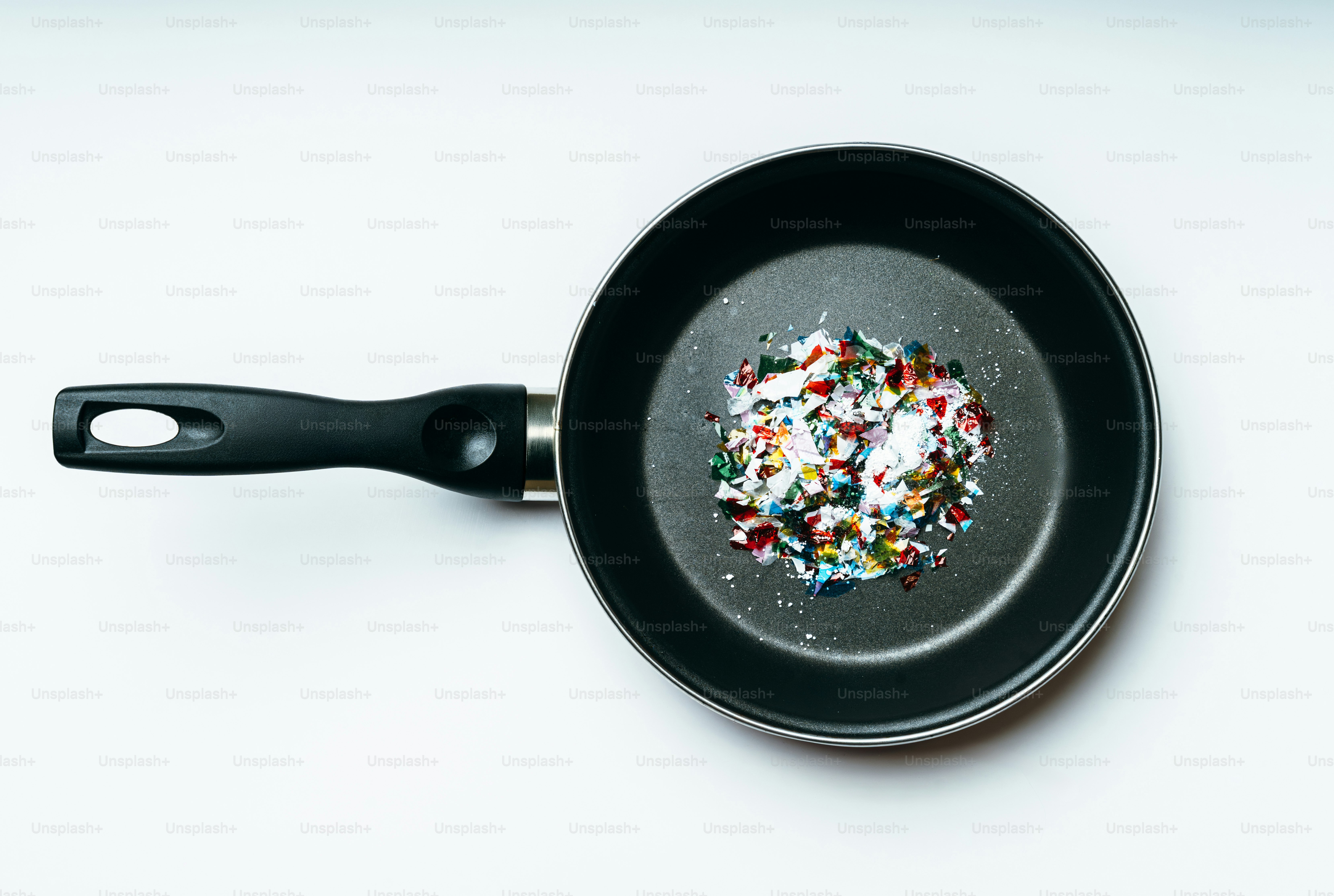 A frying pan with colorful plastic pieces inside