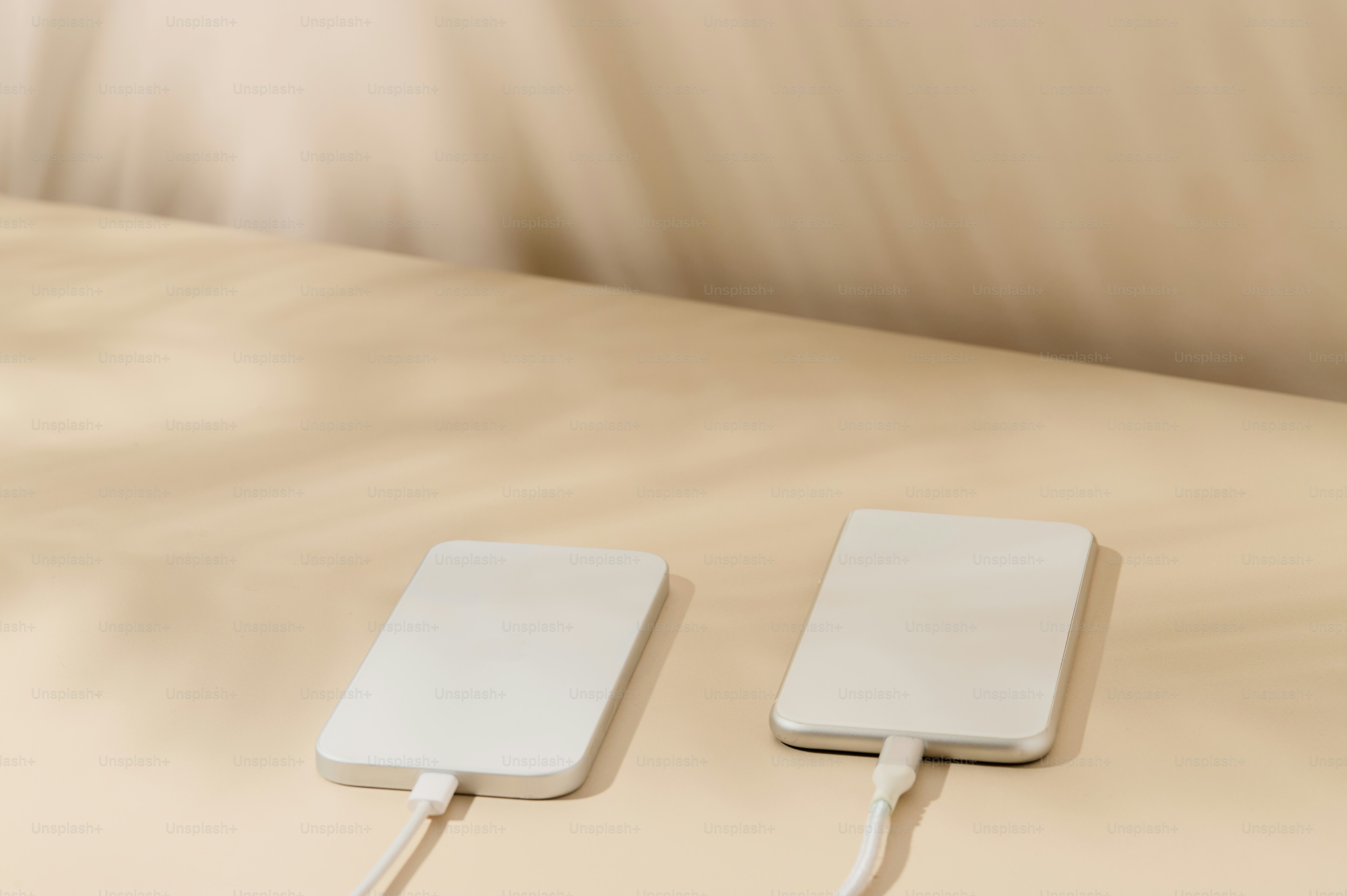 Two white wireless charging pads on a light surface.