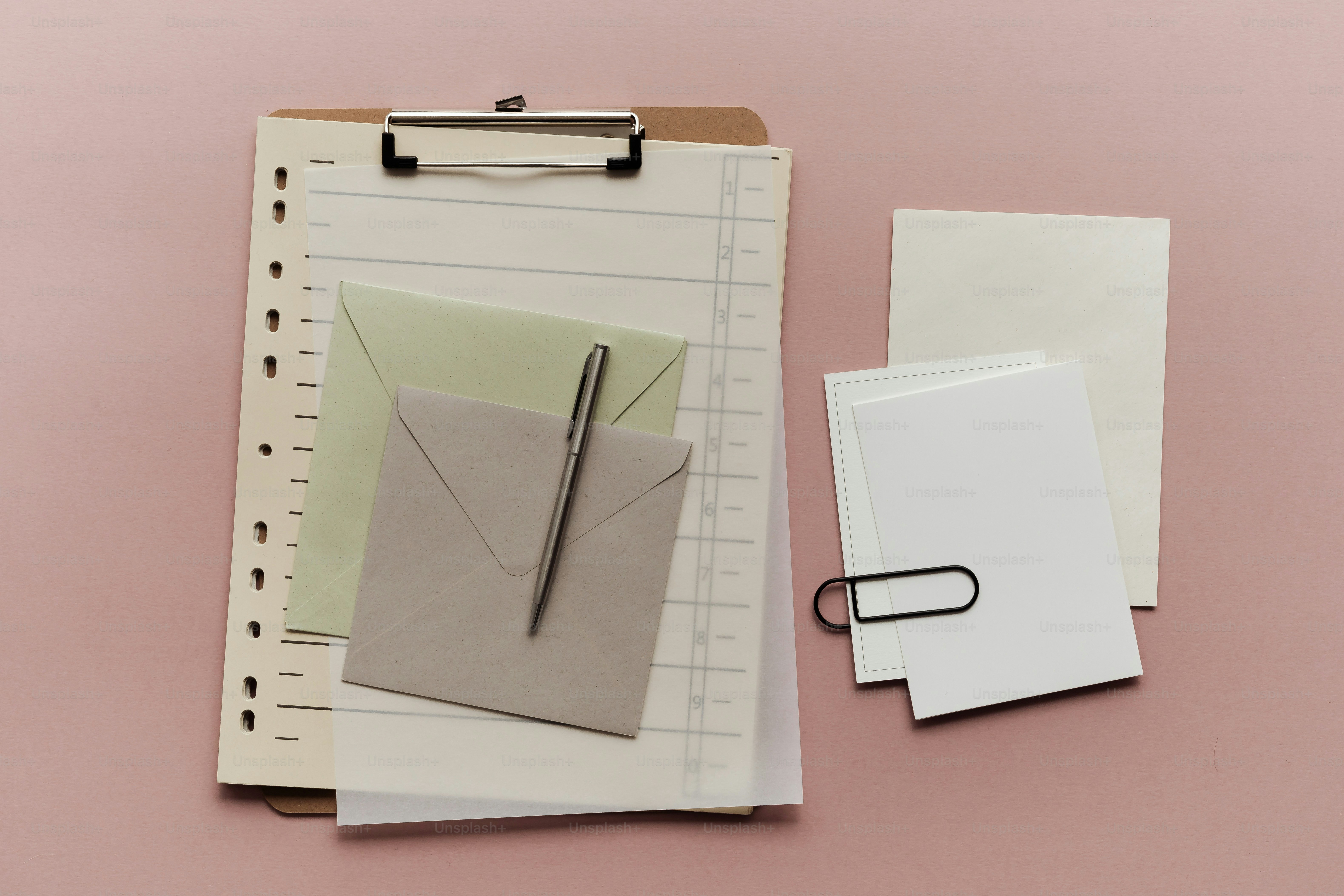 Stationery and envelopes on a pink background.