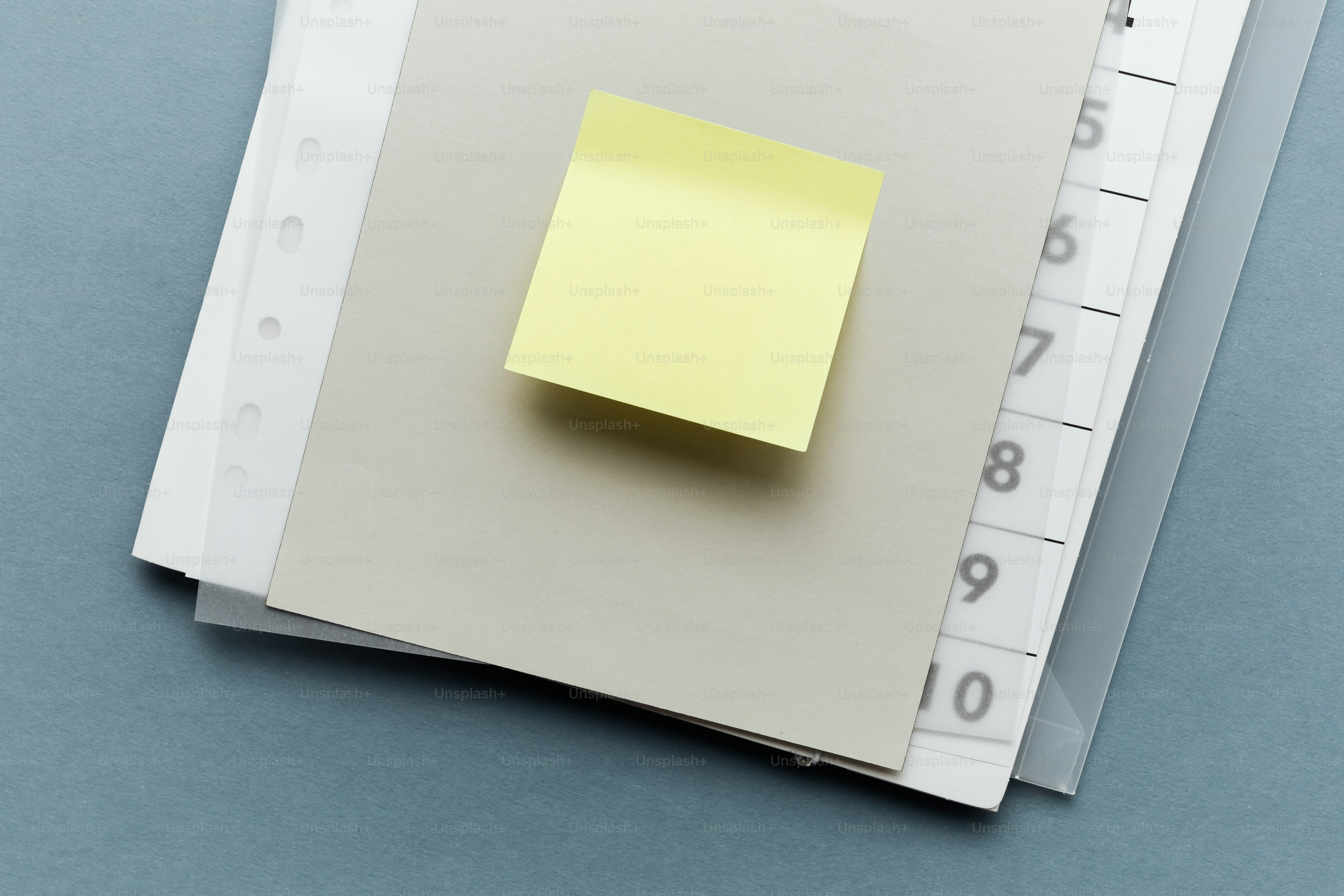 Um post-it amarelo em um caderno cinza.