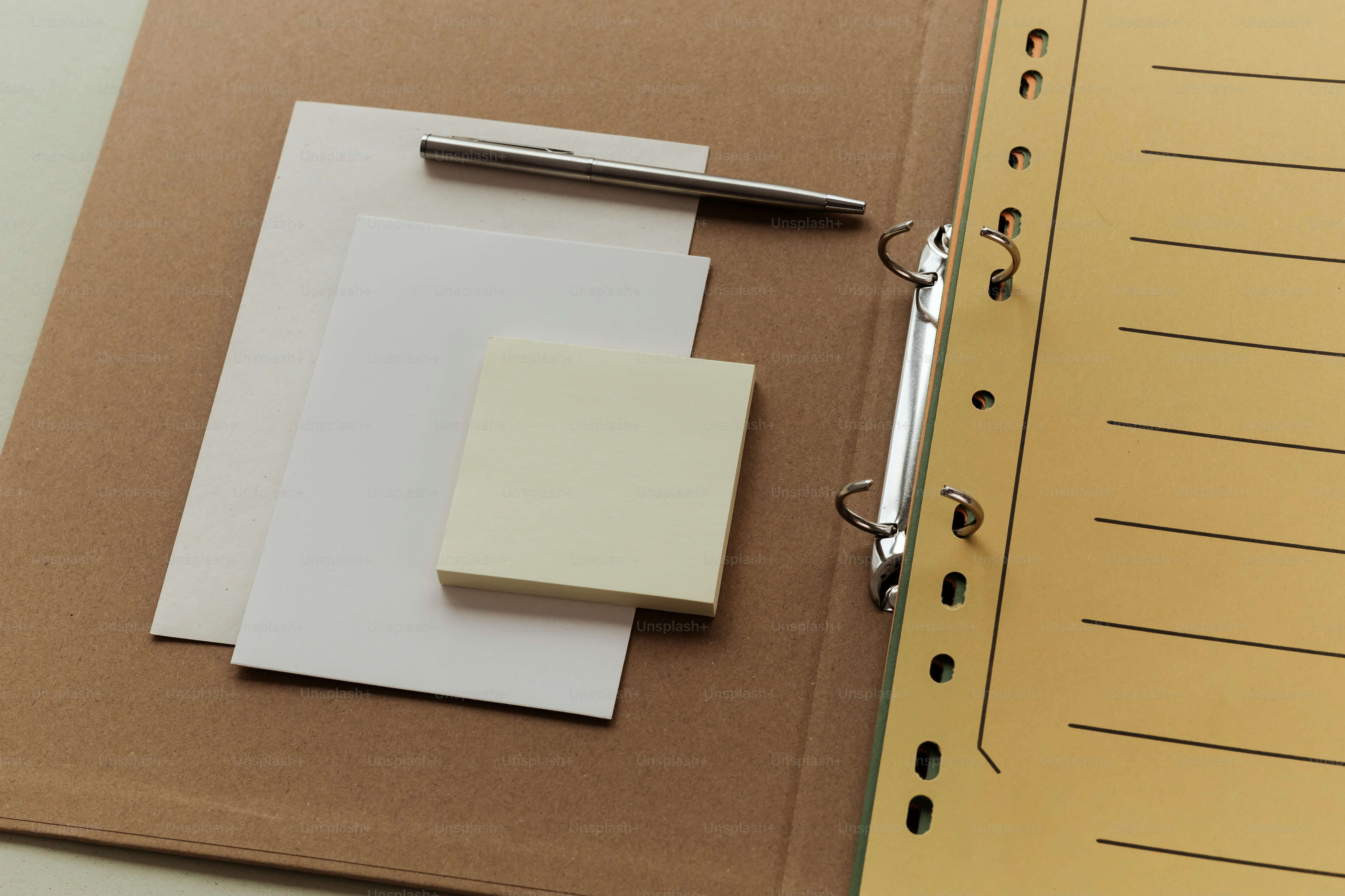 A pen rests on papers inside a binder.