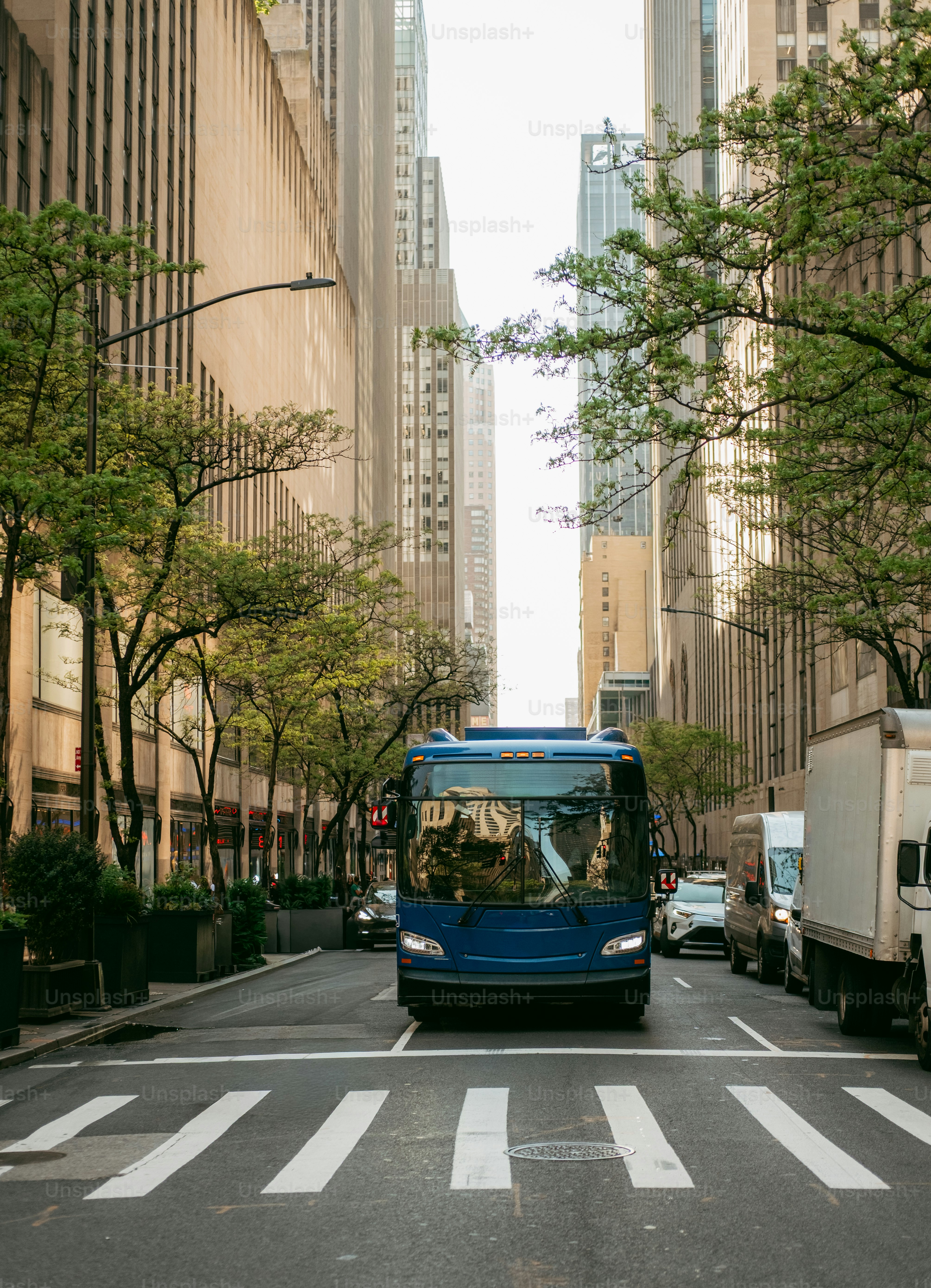 Blue bus driving down a city street.