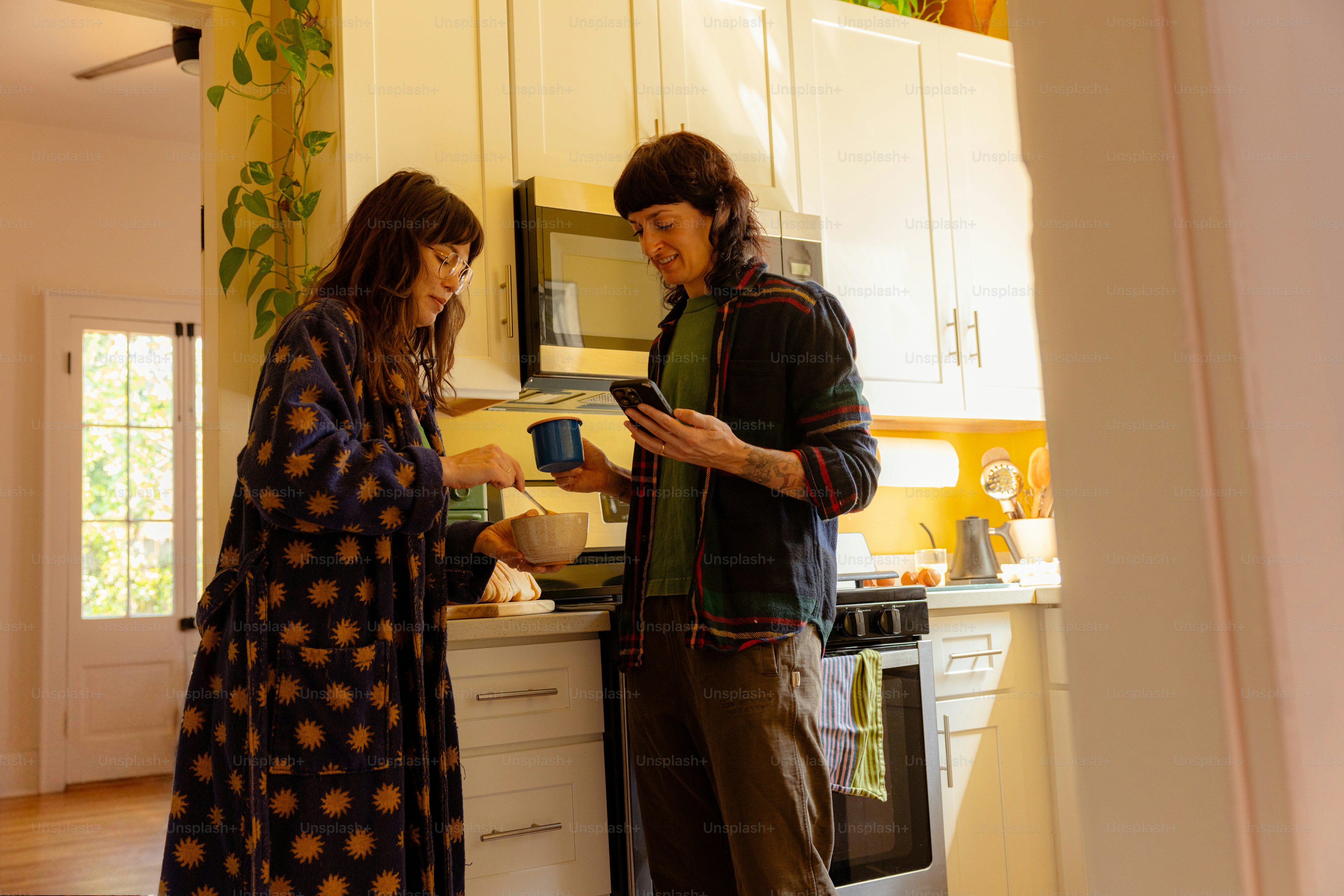 Una pareja preparando el desayuno en una cocina luminosa.