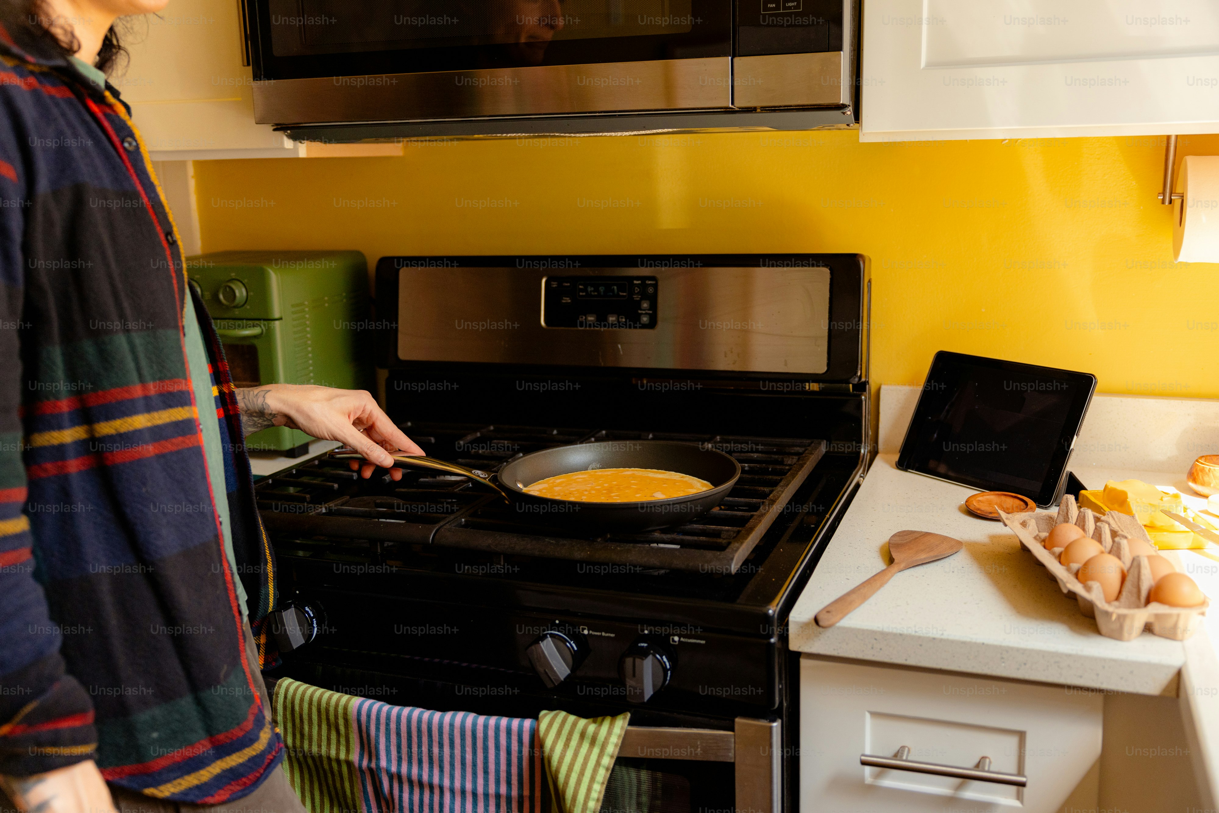 Persona cocinando huevos en una cocina en la cocina.