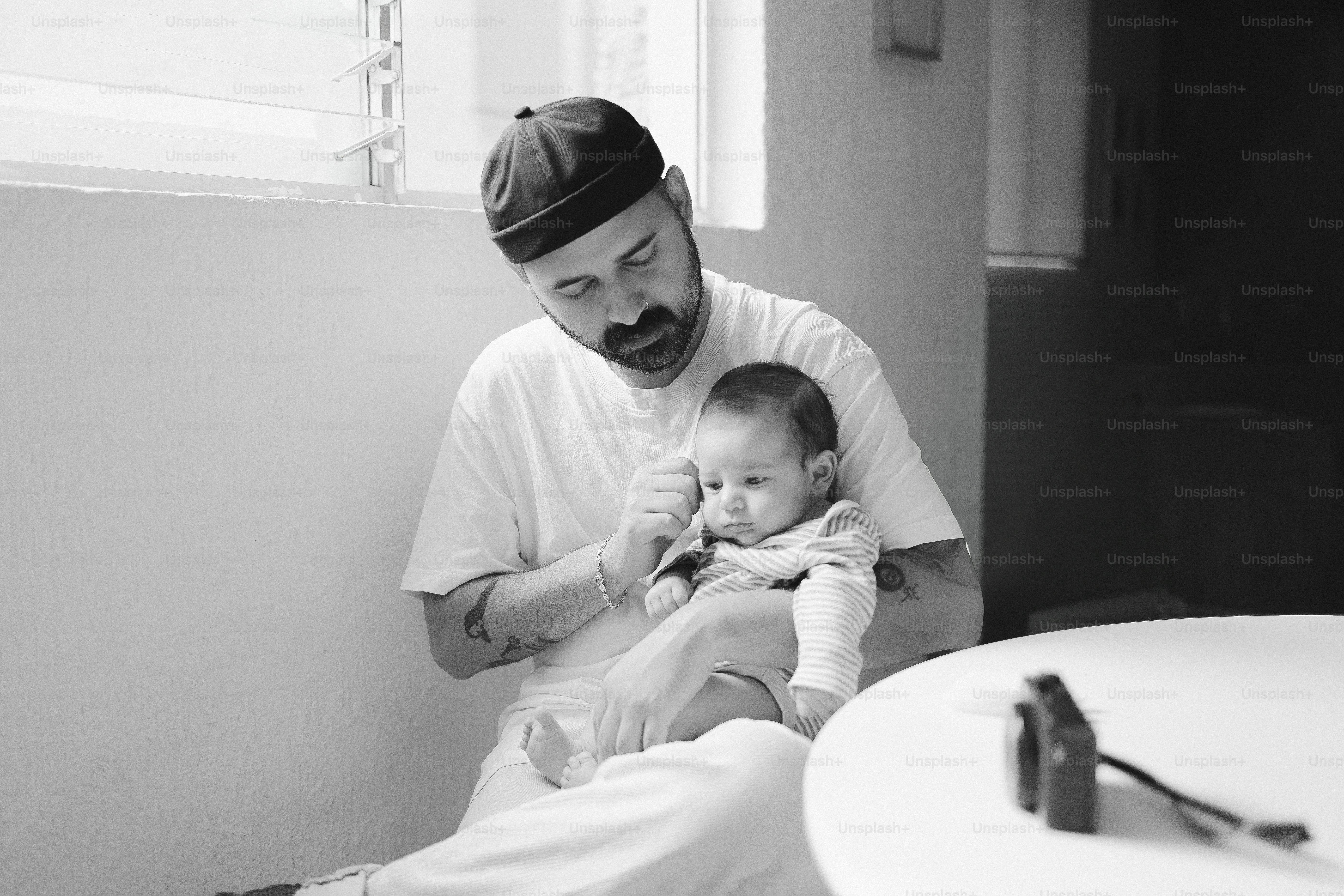 Homme au chapeau tenant un bébé