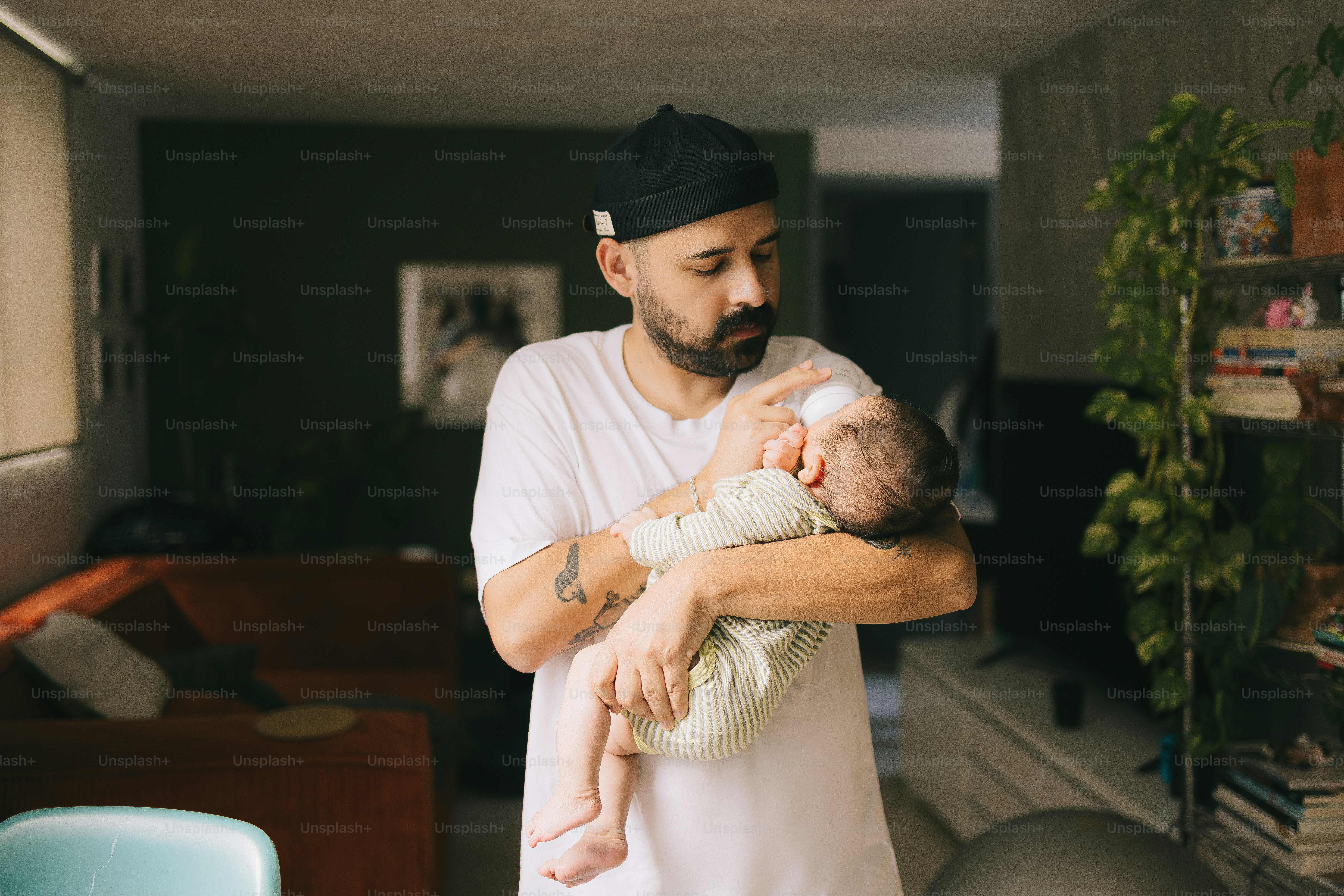 Un homme tenant un nouveau-né endormi à l’intérieur