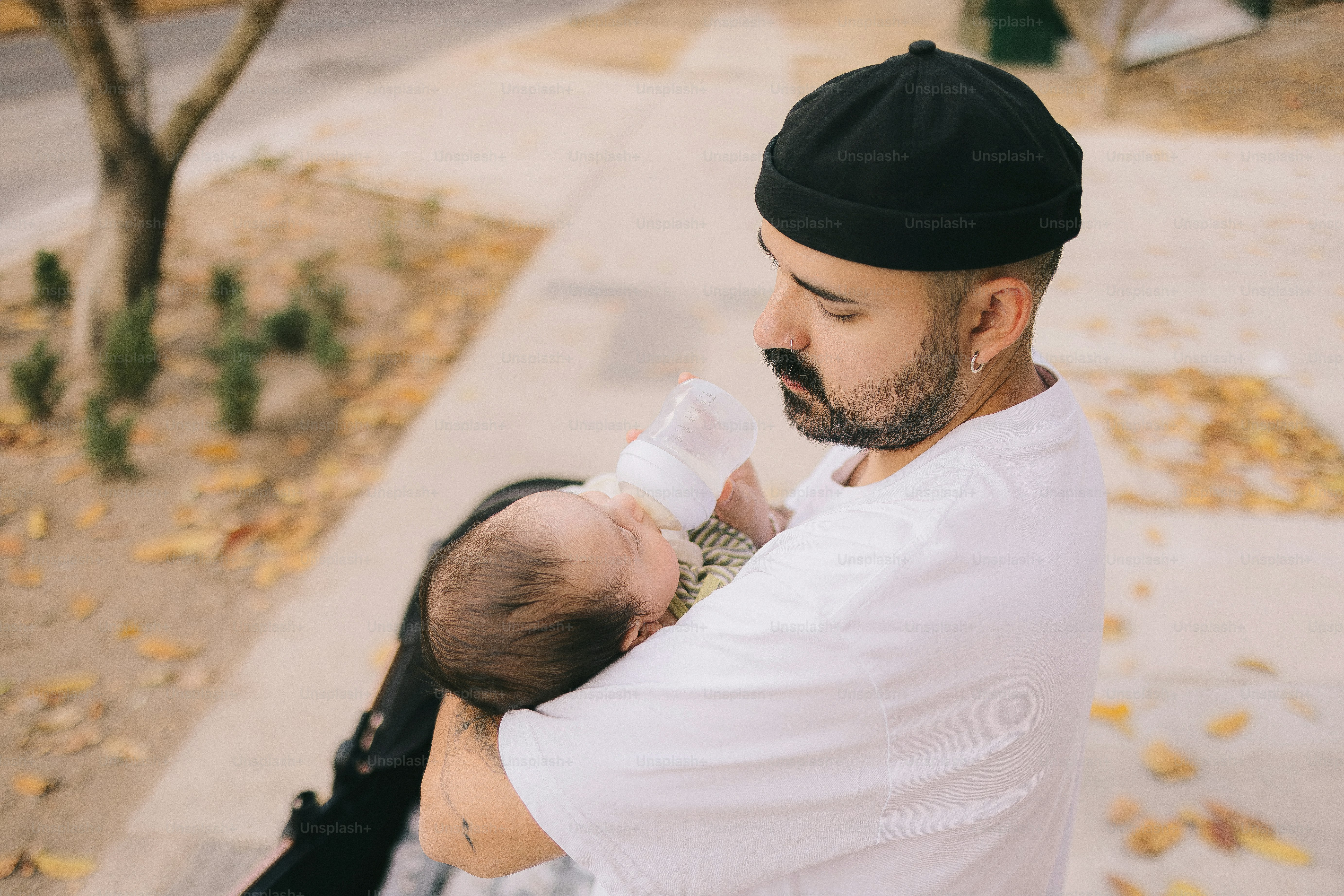 Un père tenant un bébé dehors en plein jour.