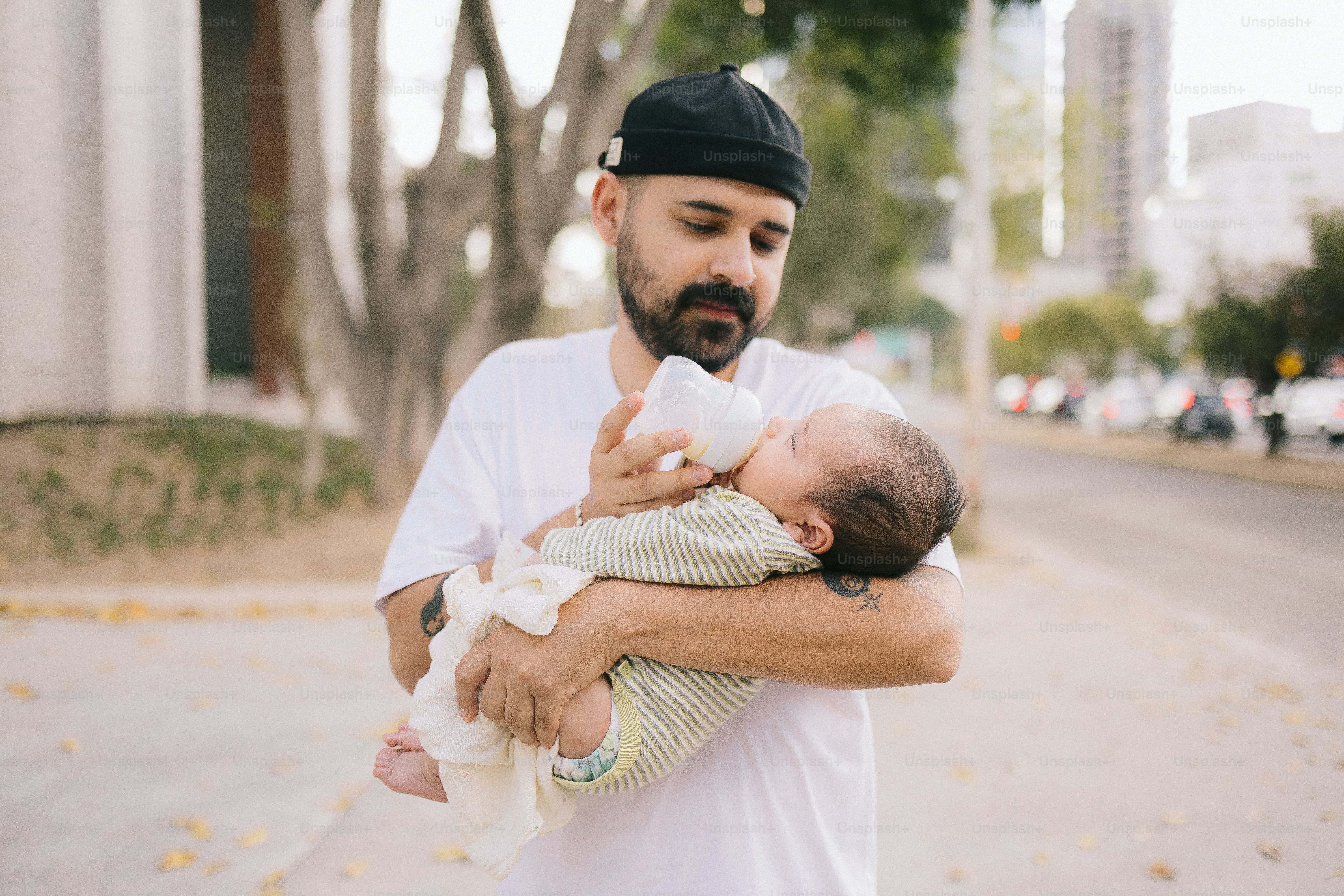 Un homme nourrissant un bébé avec un biberon dehors