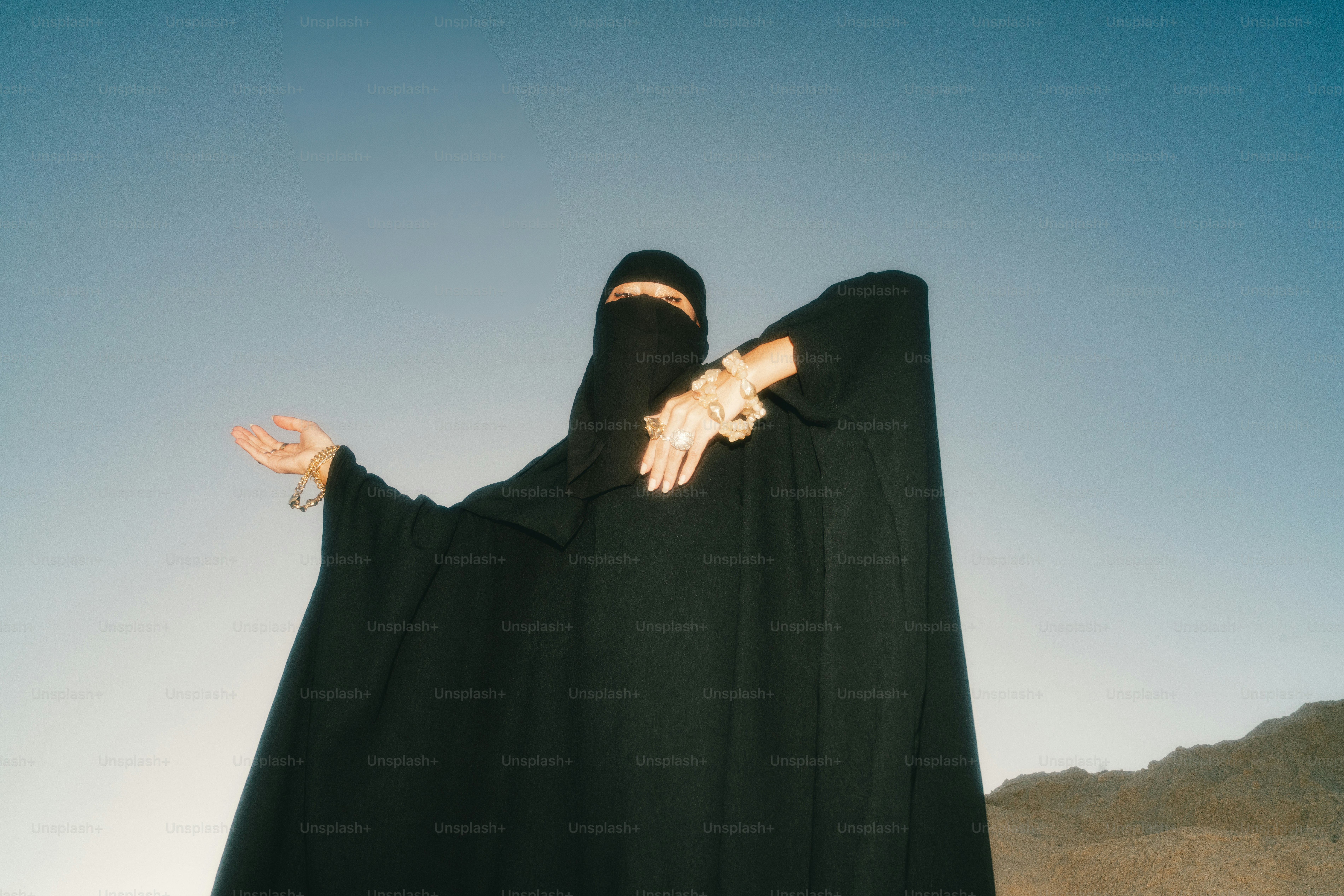 Wanita berbaju abaya hitam dan niqab dengan perhiasan
