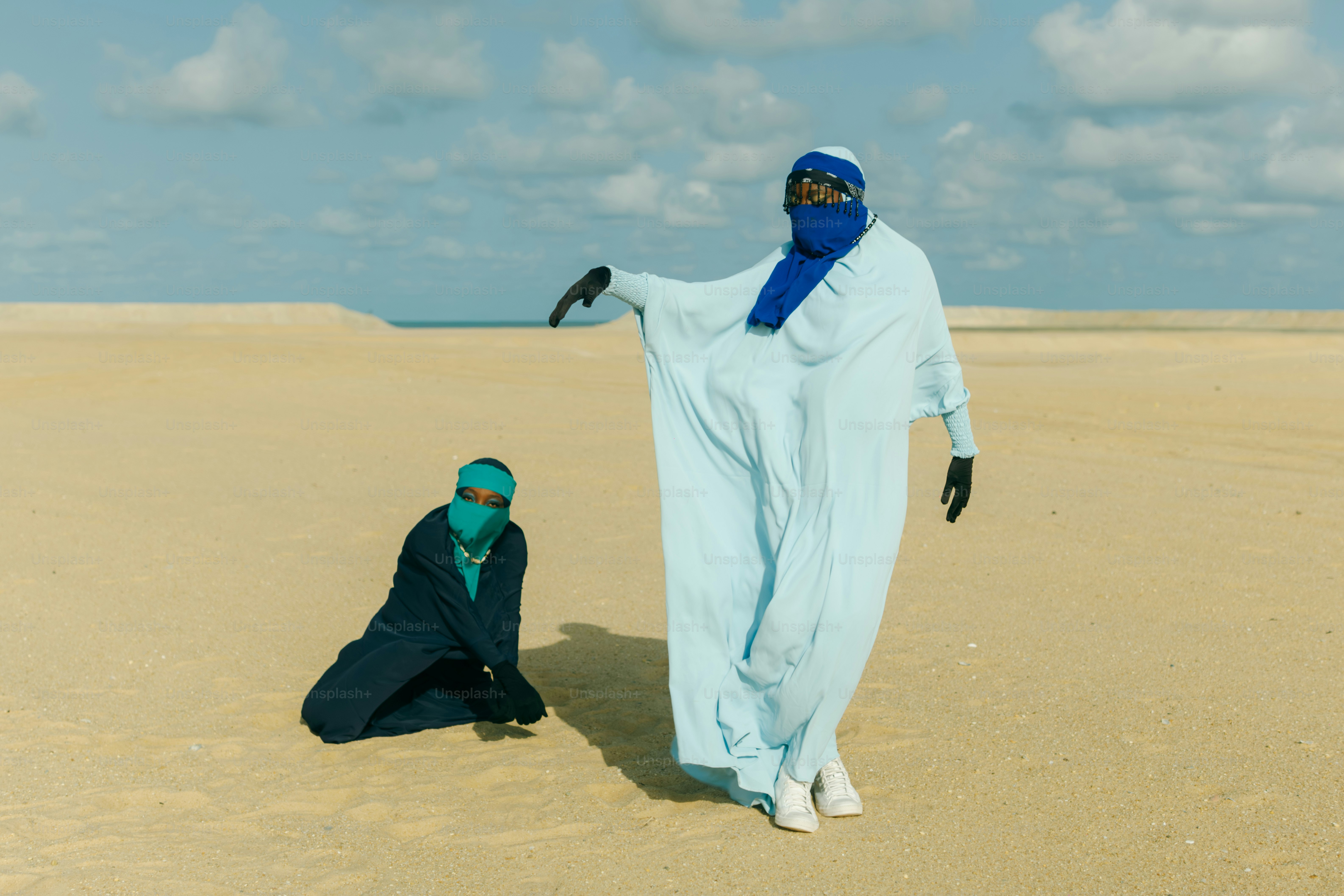 Deux personnes en vêtements traditionnels dans un paysage désertique.