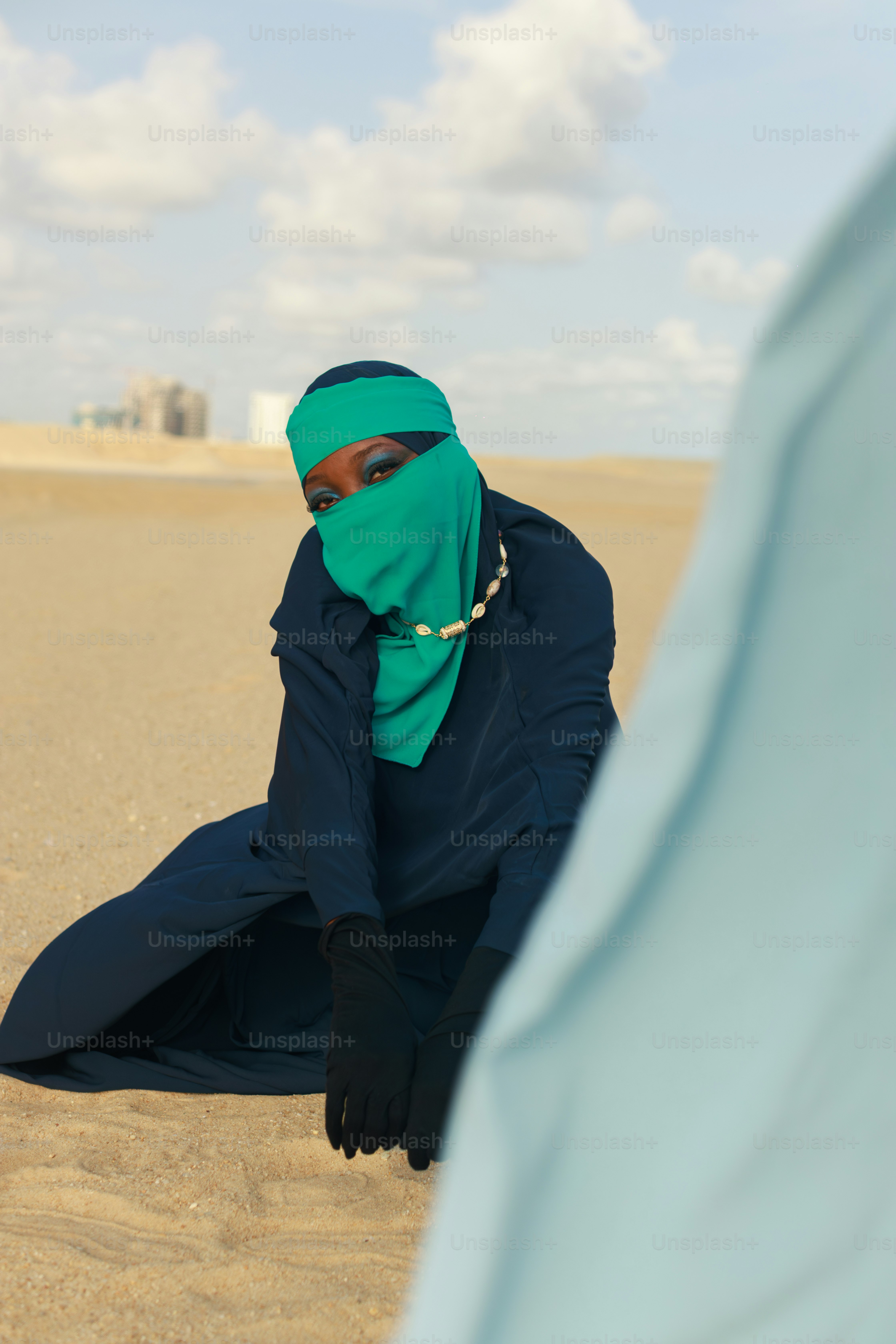 Femme portant le hijab et une robe bleu foncé dans le désert