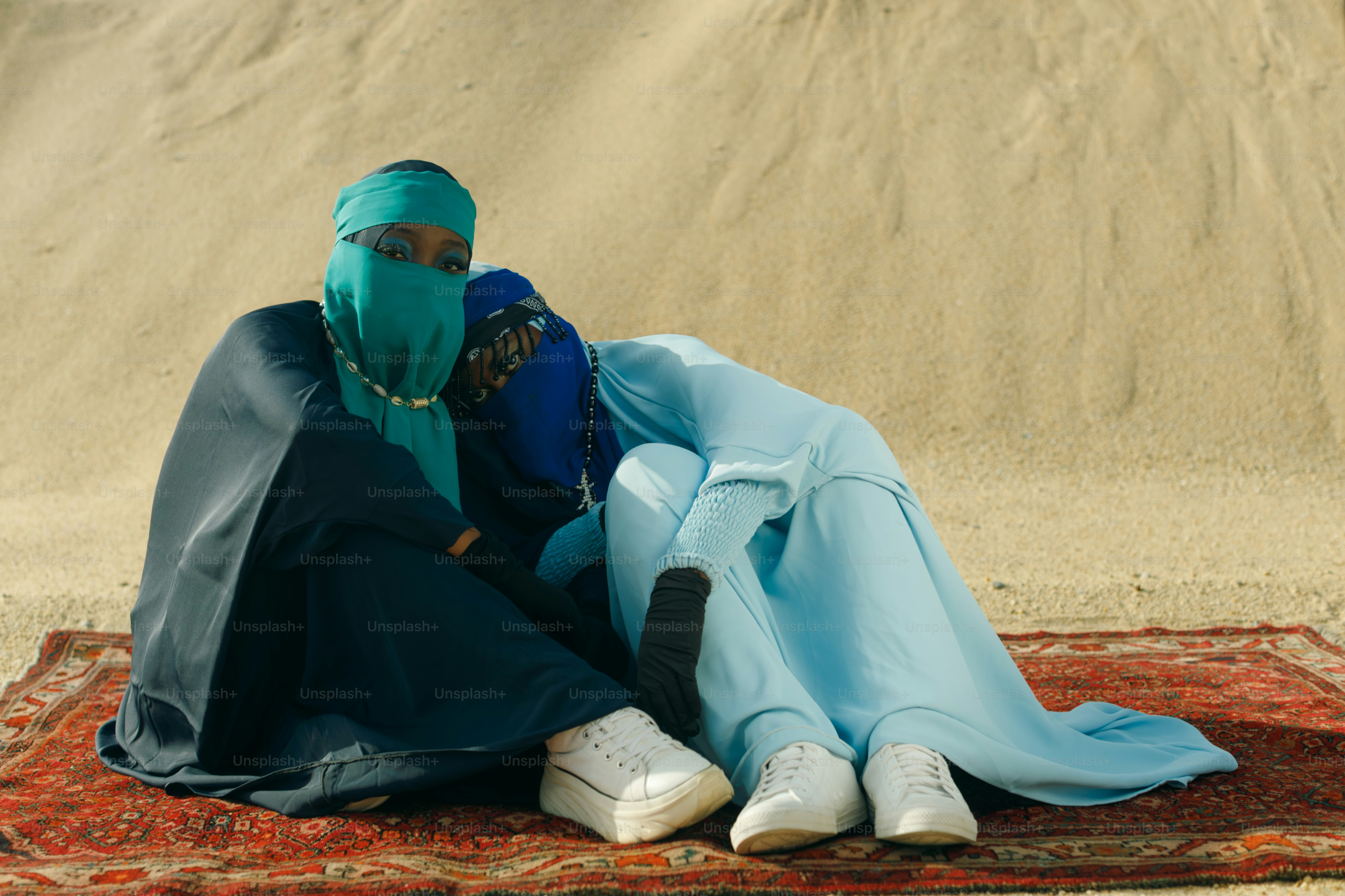 Deux personnes en vêtements traditionnels reposant sur un tapis