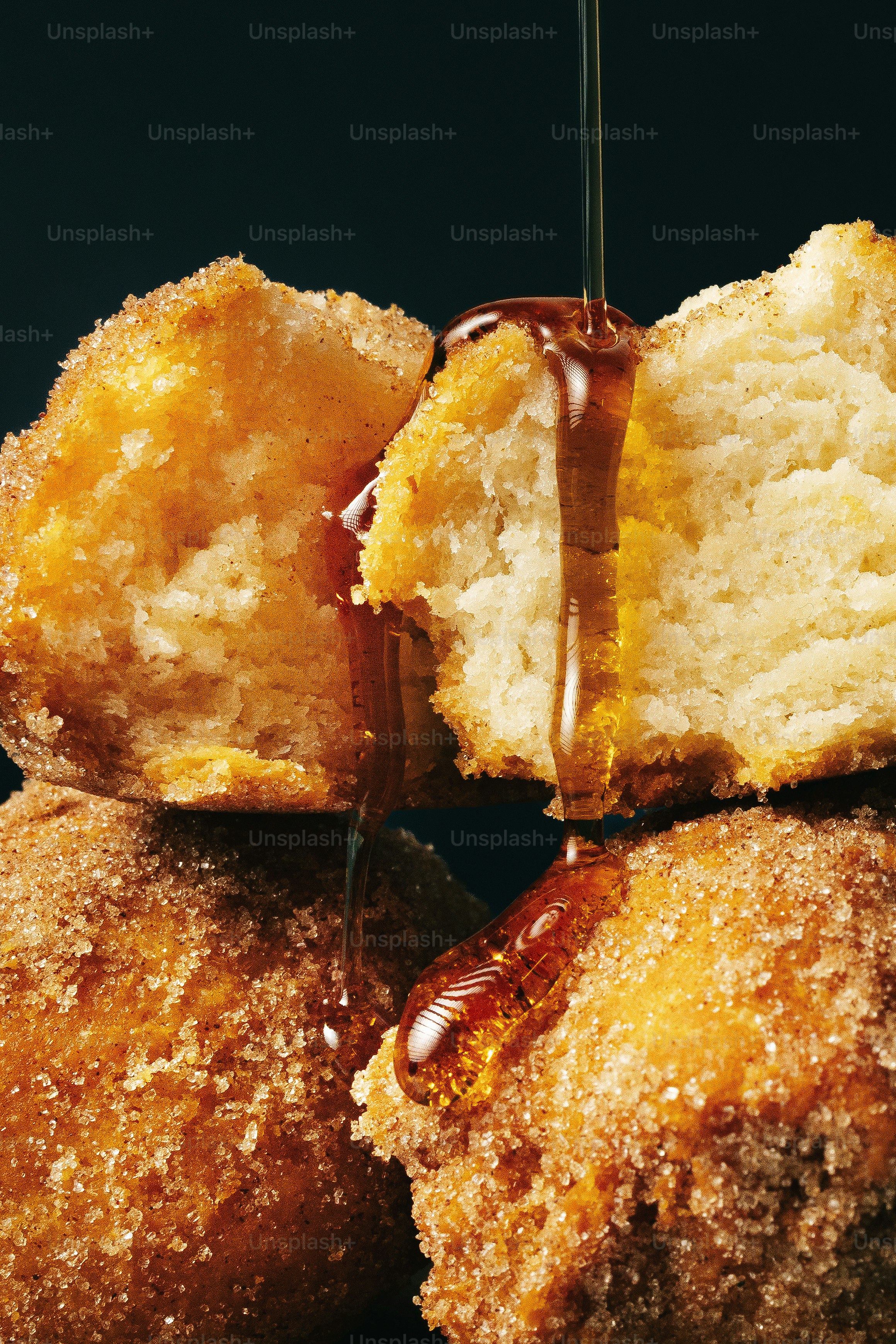 Du miel qui coule sur des pâtisseries enrobées de cannelle et de sucre