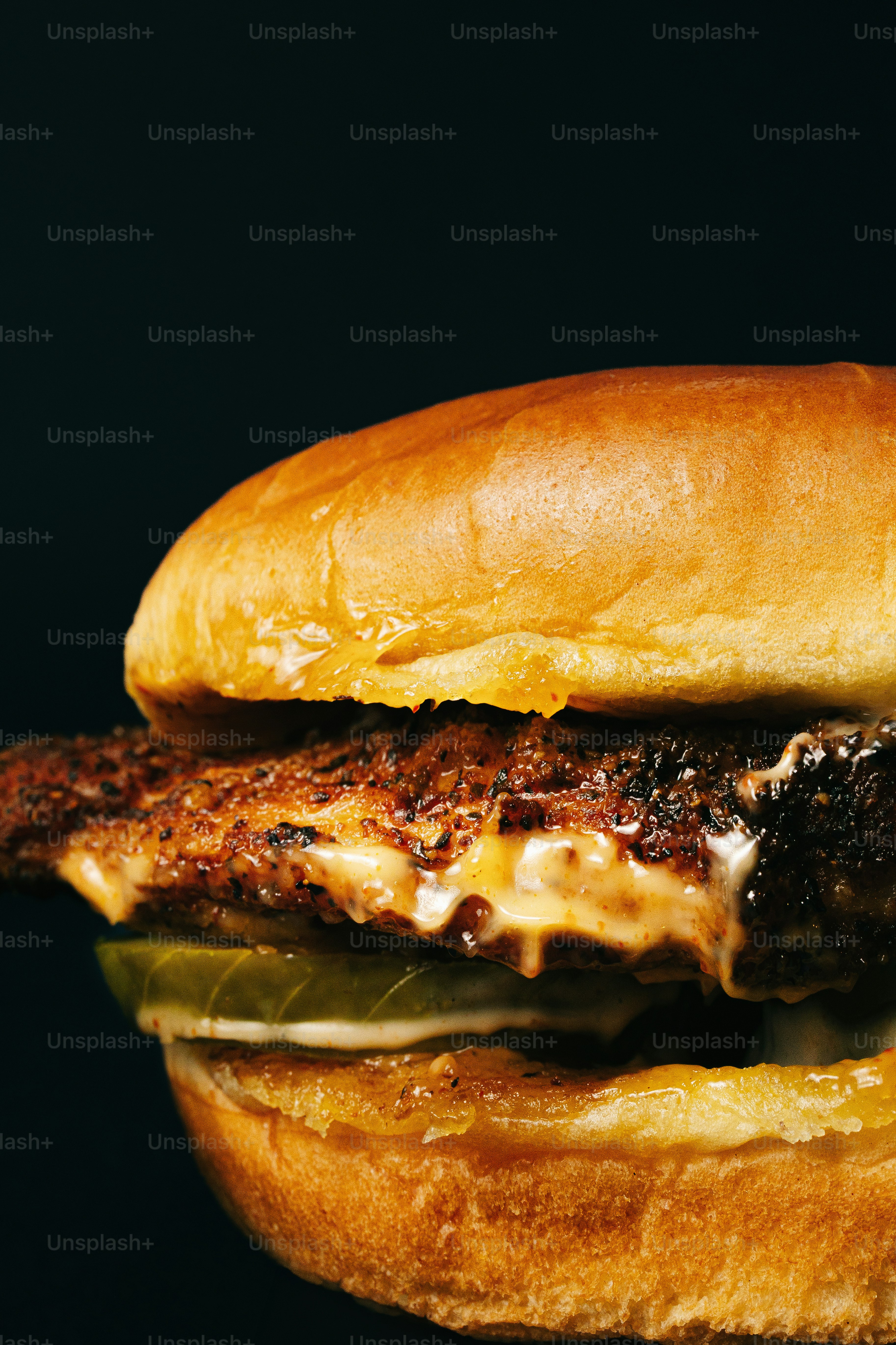 Un burger juteux avec du fromage fondu et des cornichons