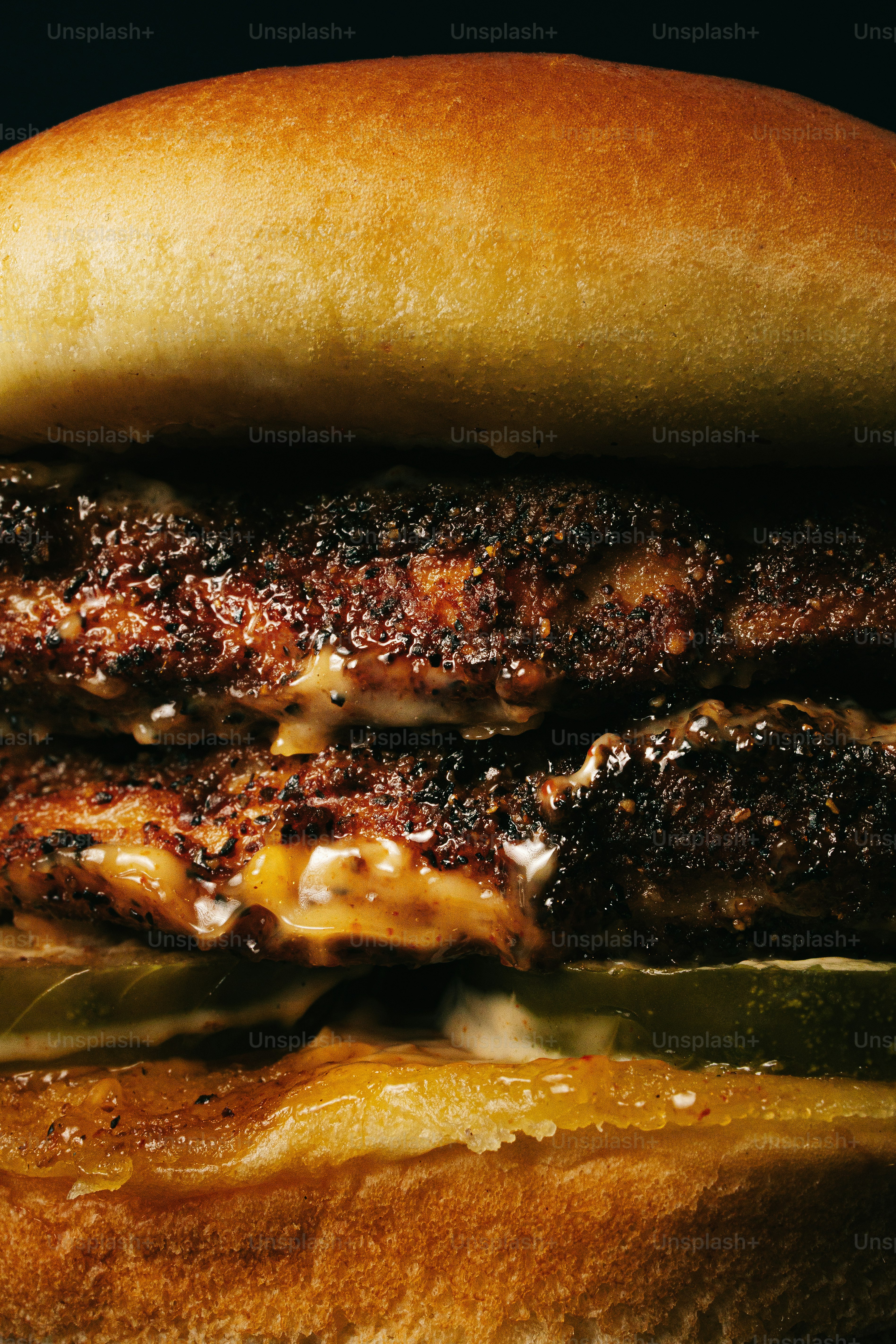 Un gros plan d’un double cheeseburger juteux avec des cornichons.