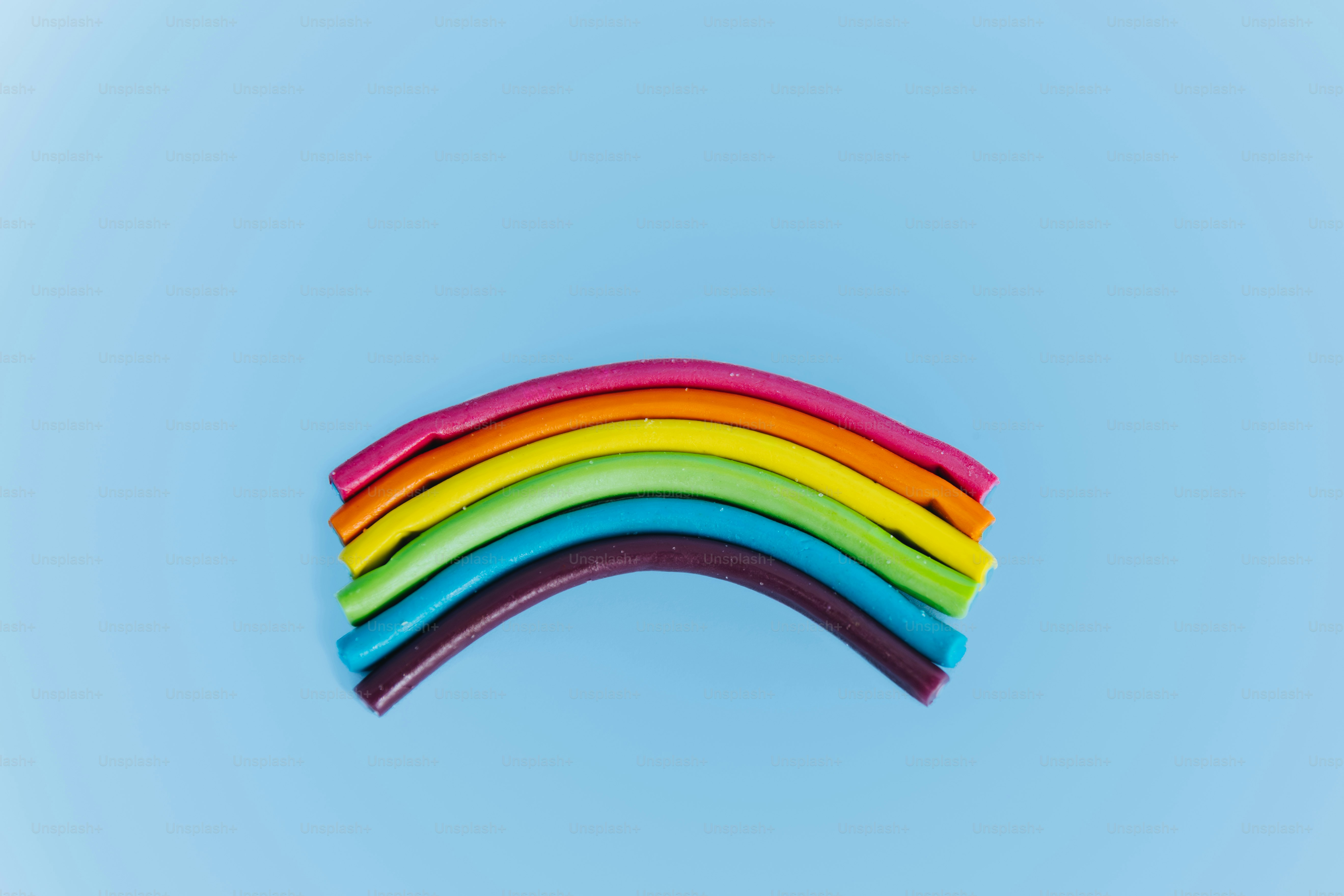 Arcobaleno colorato fatto di argilla su sfondo blu
