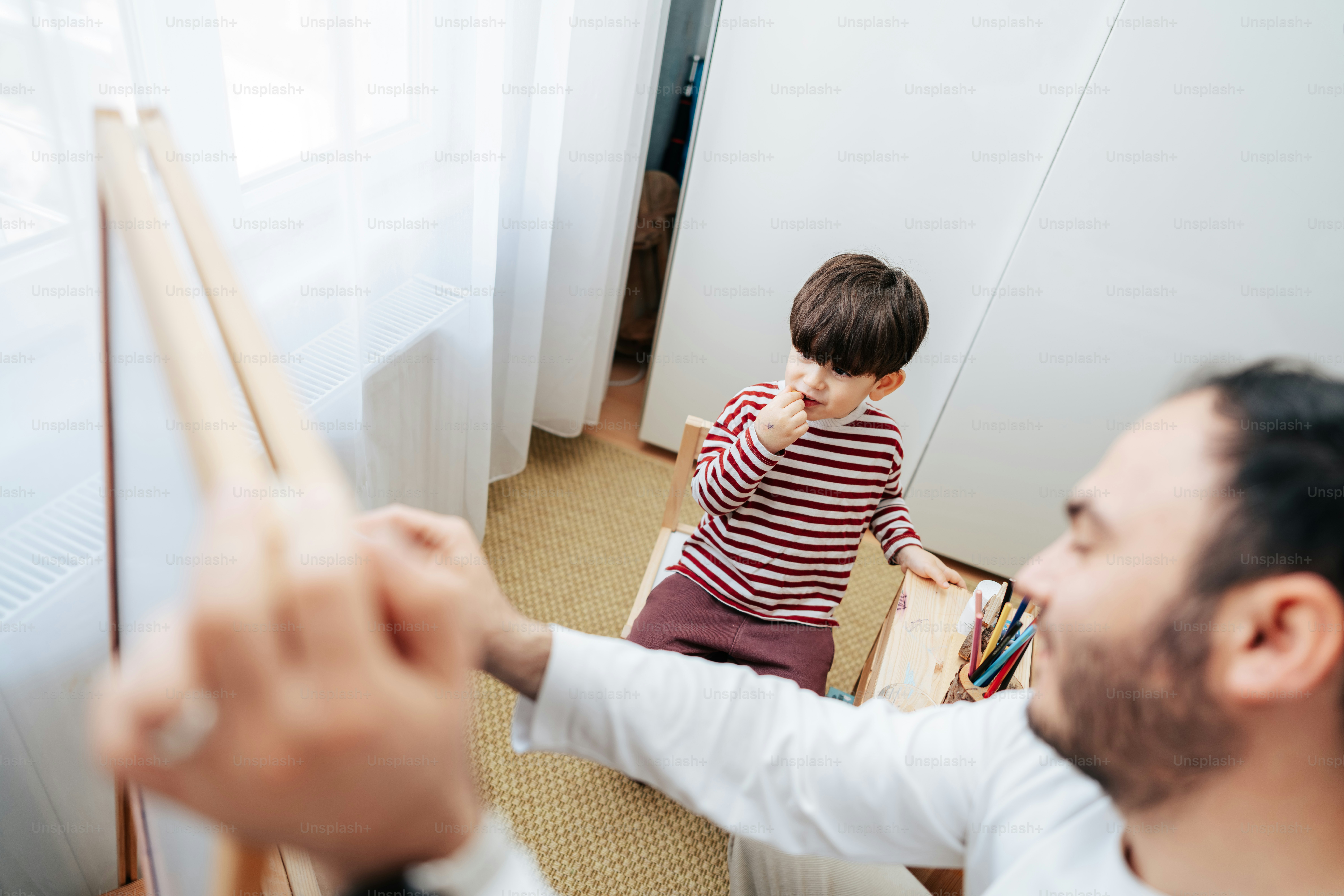 Ayah dan anak melukis bersama di kuda-kuda.