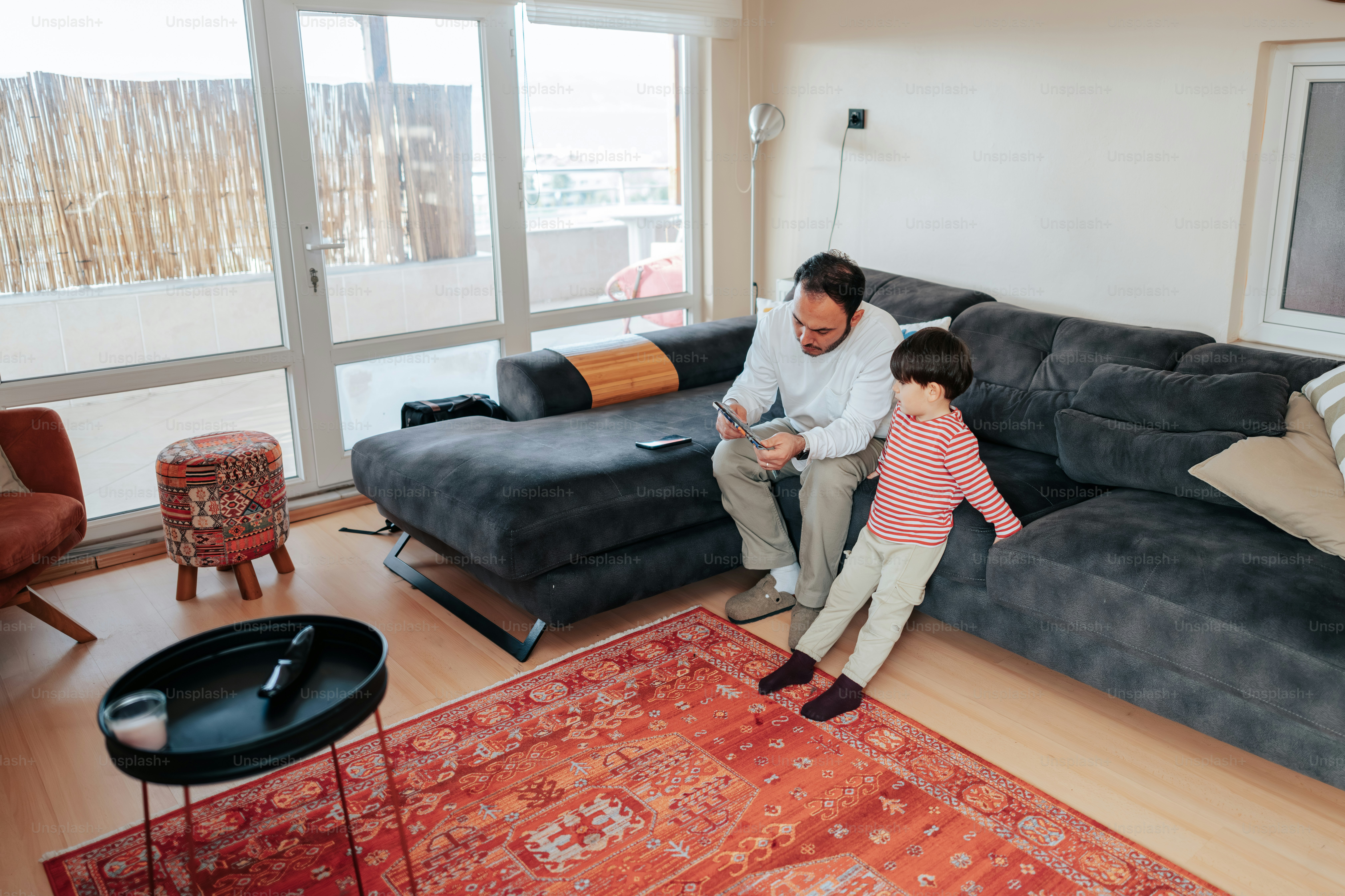 Ayah dan anak duduk di sofa bersama