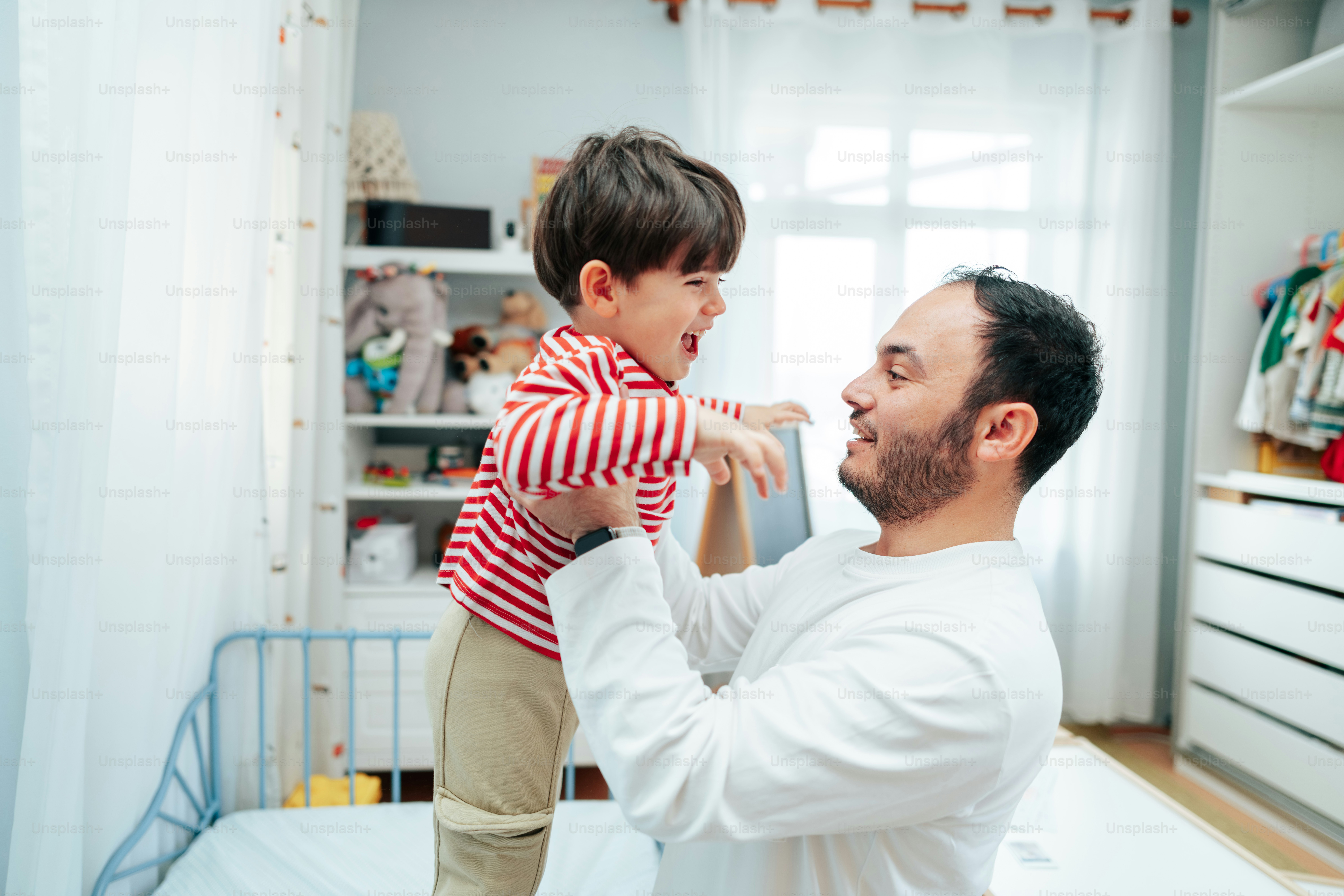Ayah mengangkat putra bahagia di kamar tidur