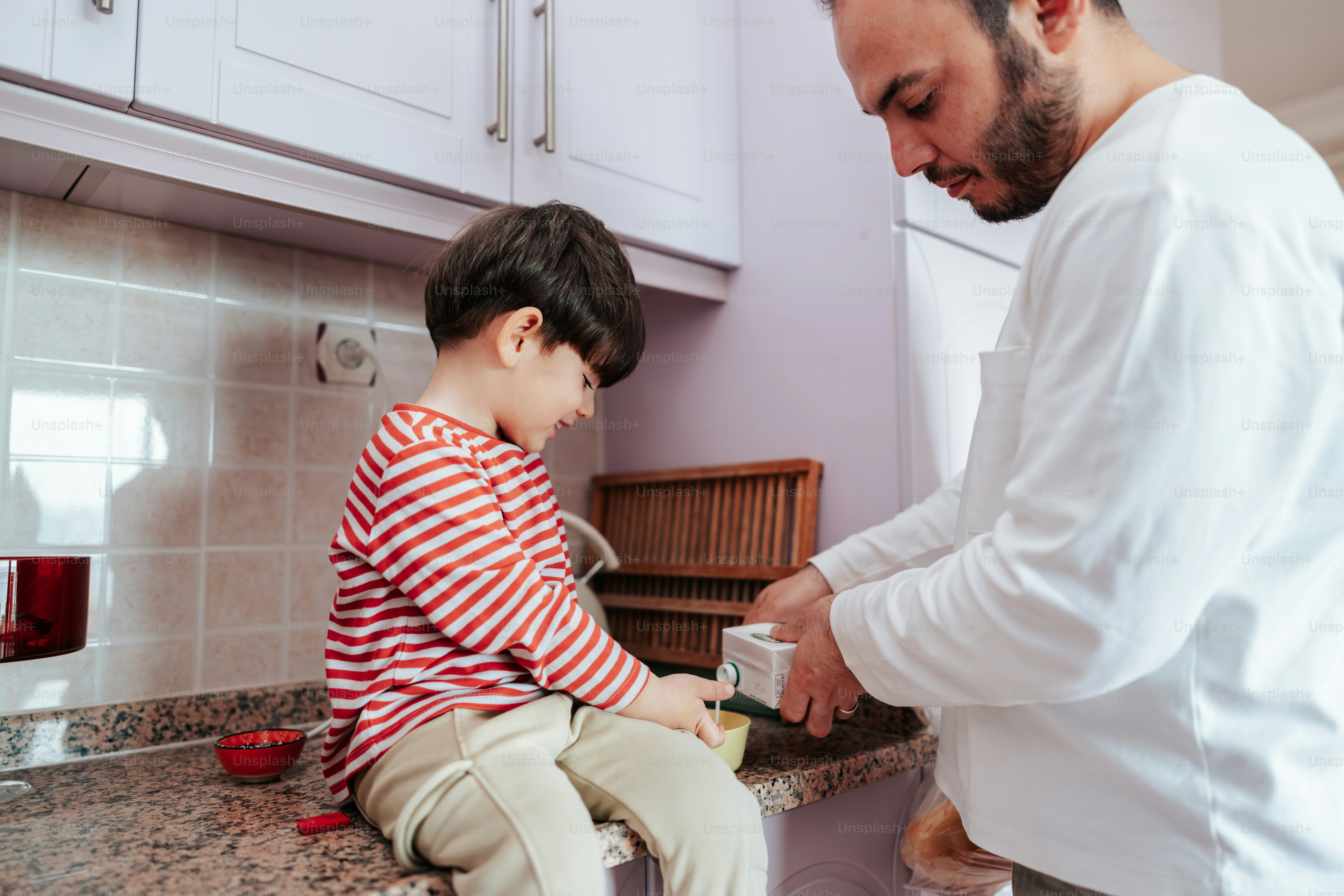 Ayah dan anak menyiapkan makanan di dapur.