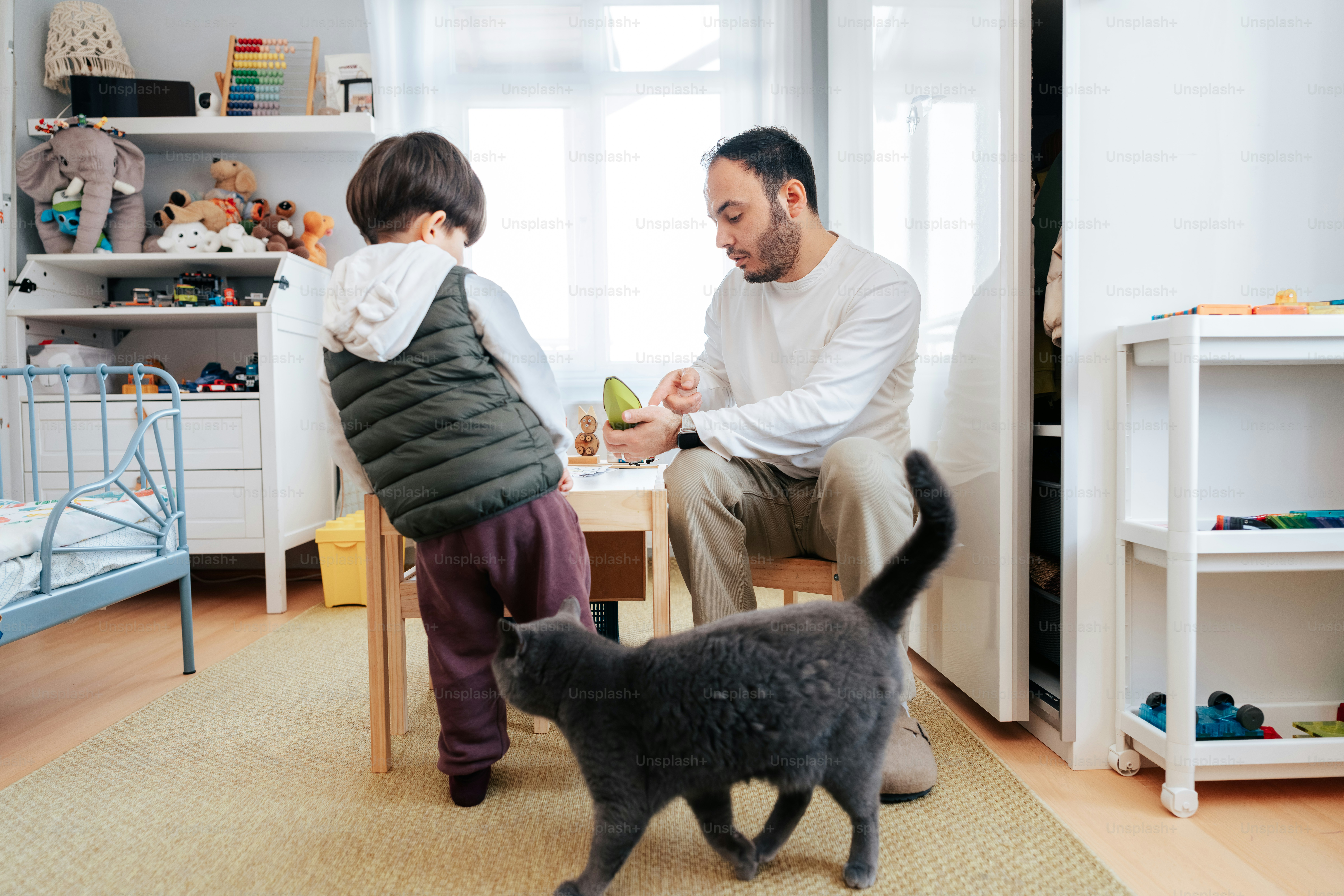 Ayah dan anak dengan kucing di ruangan yang terang