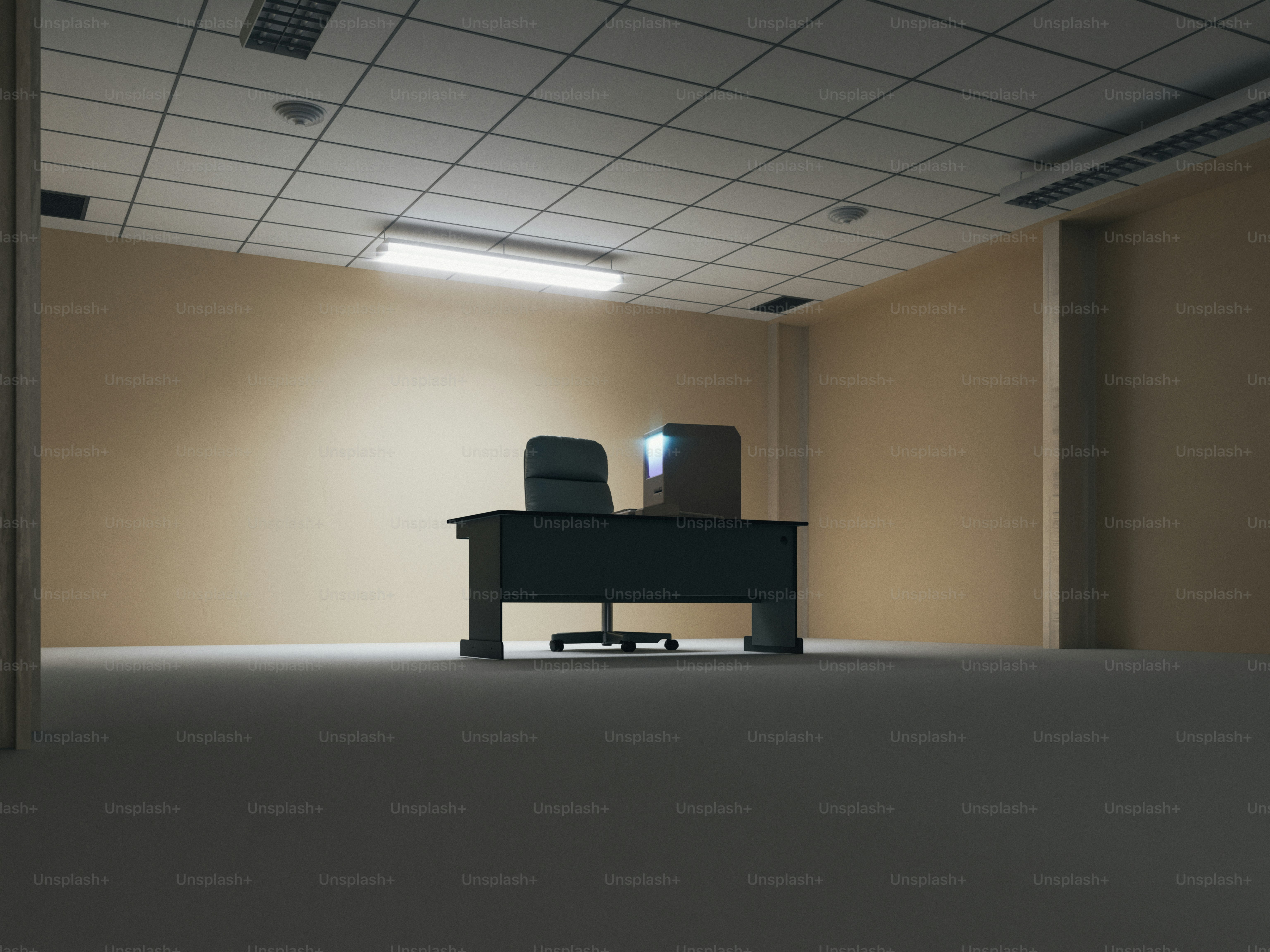 Ufficio vuoto con scrivania, sedie e computer.