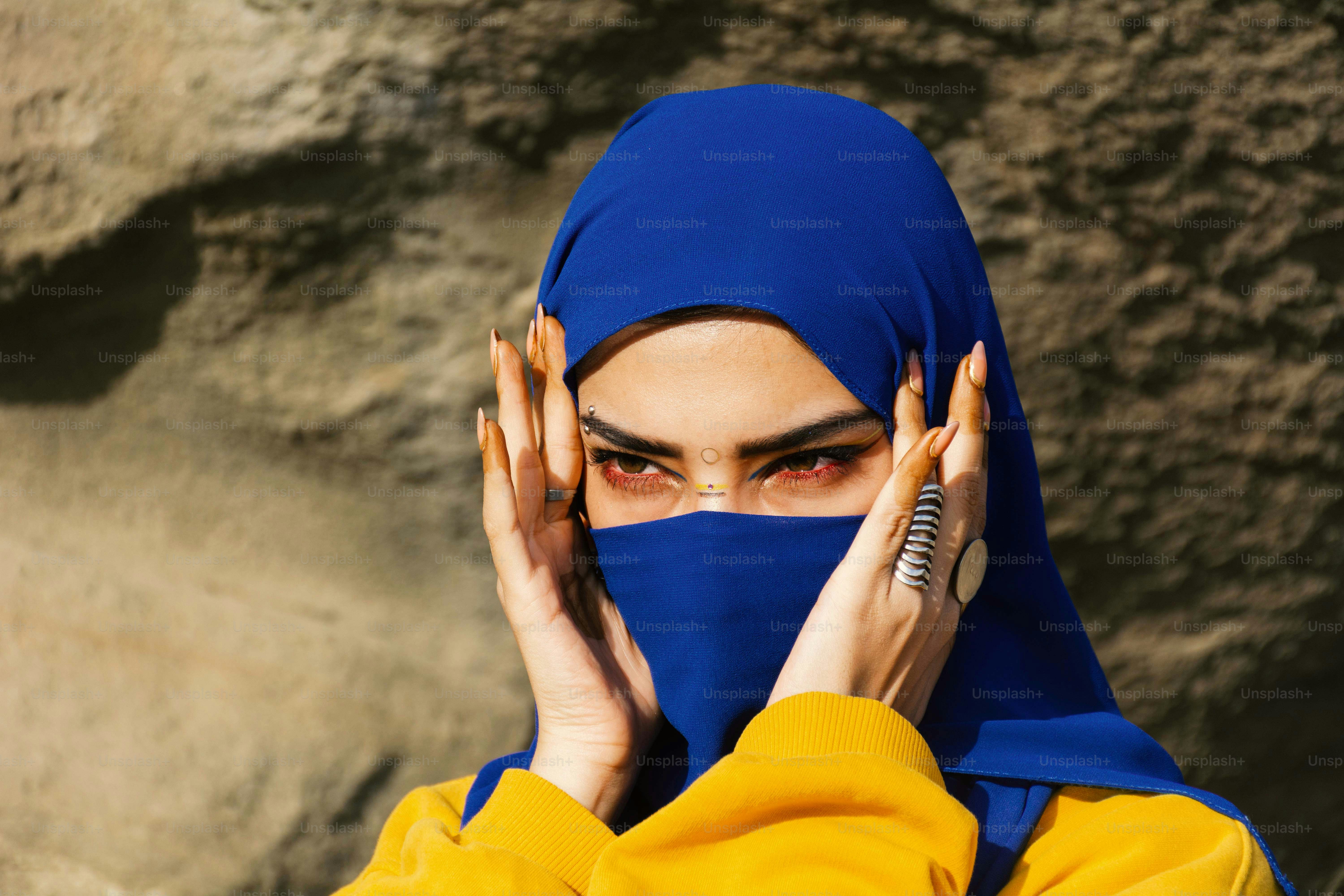 Femme en hijab bleu avec un maquillage des yeux frappant