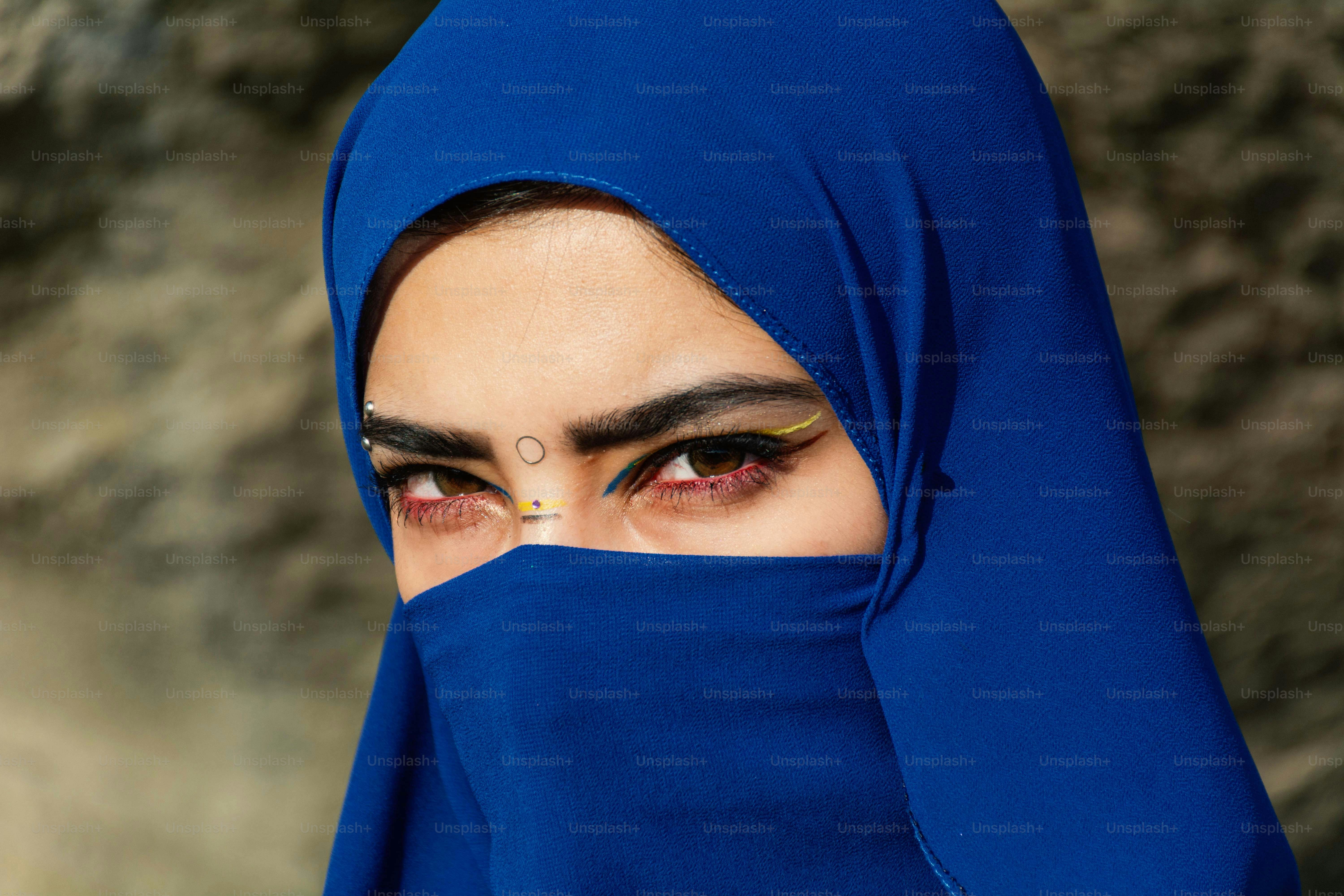 Femme portant un hijab bleu et un masque.