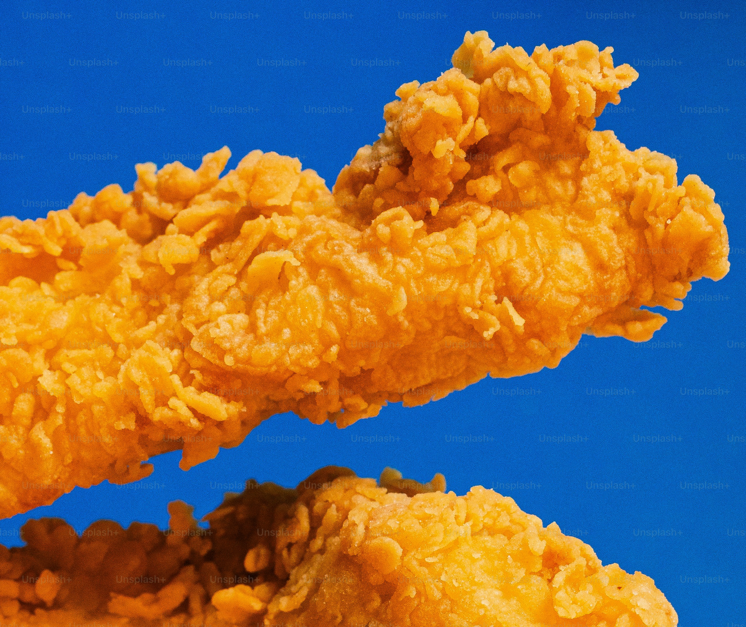 Des lanières de poulet frit croustillantes sur fond bleu