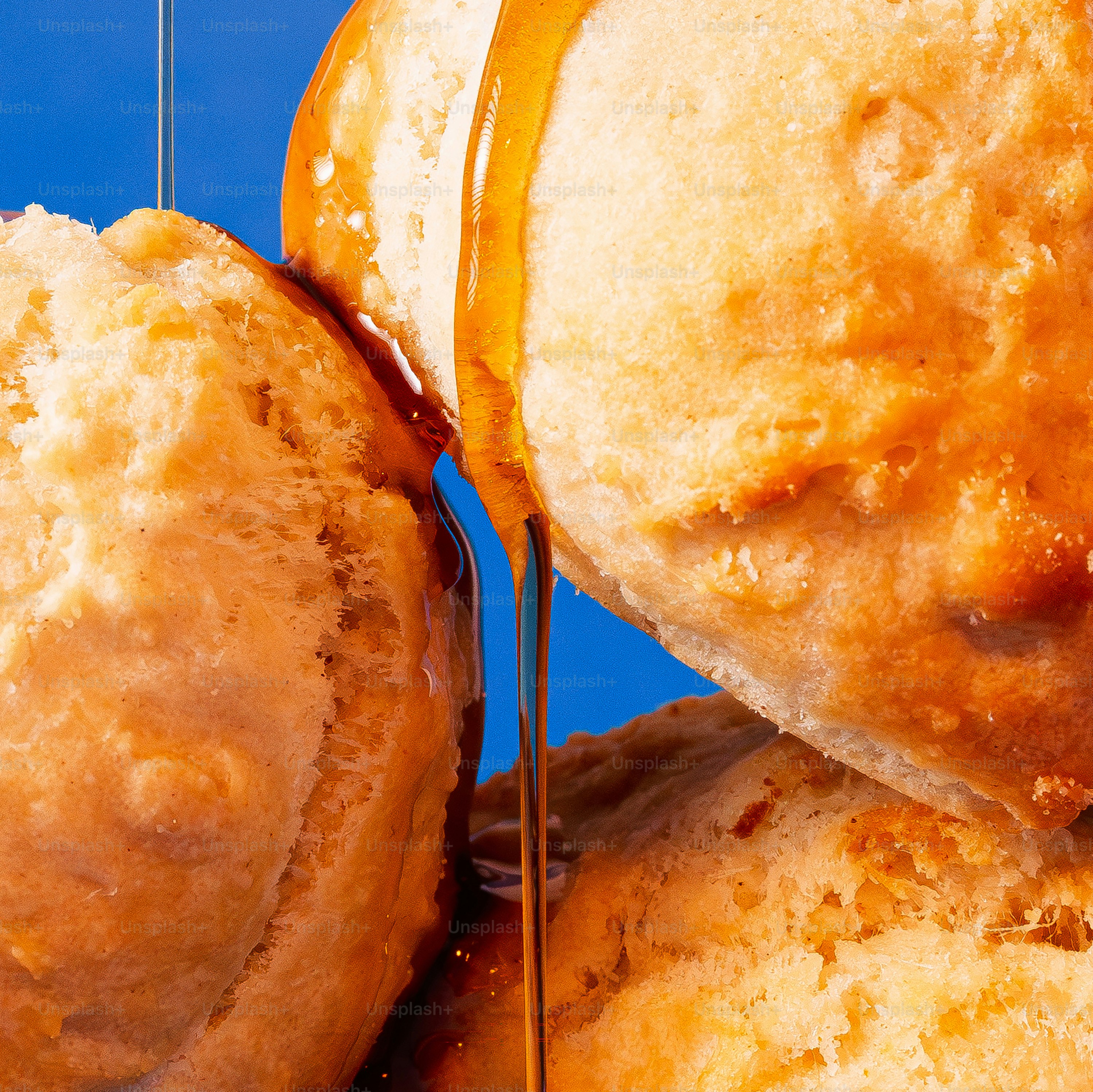 Le sirop dégoulinant sur des biscuits moelleux sur fond bleu