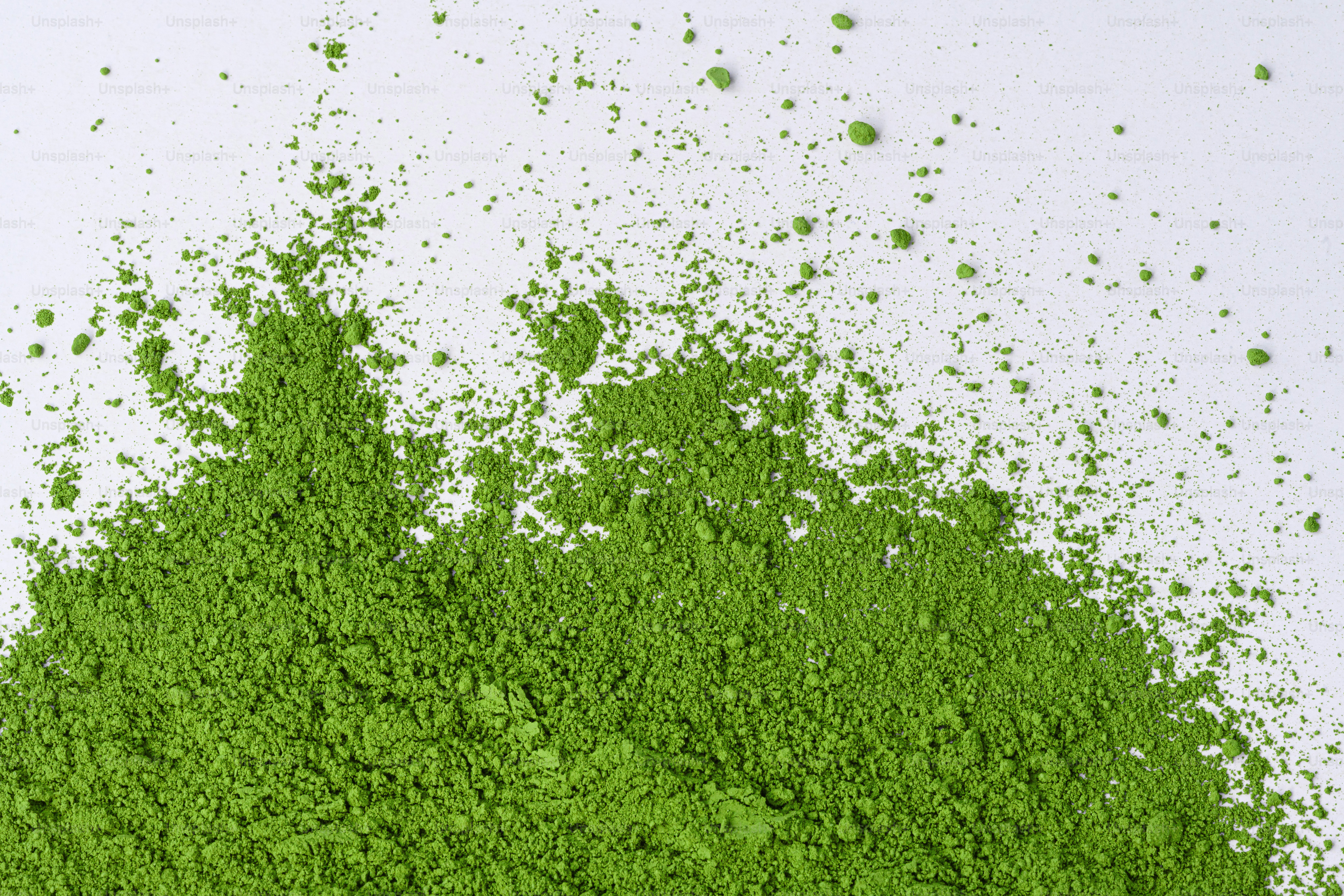 A pile of vibrant green matcha powder scattered. photo – Wellness Image ...