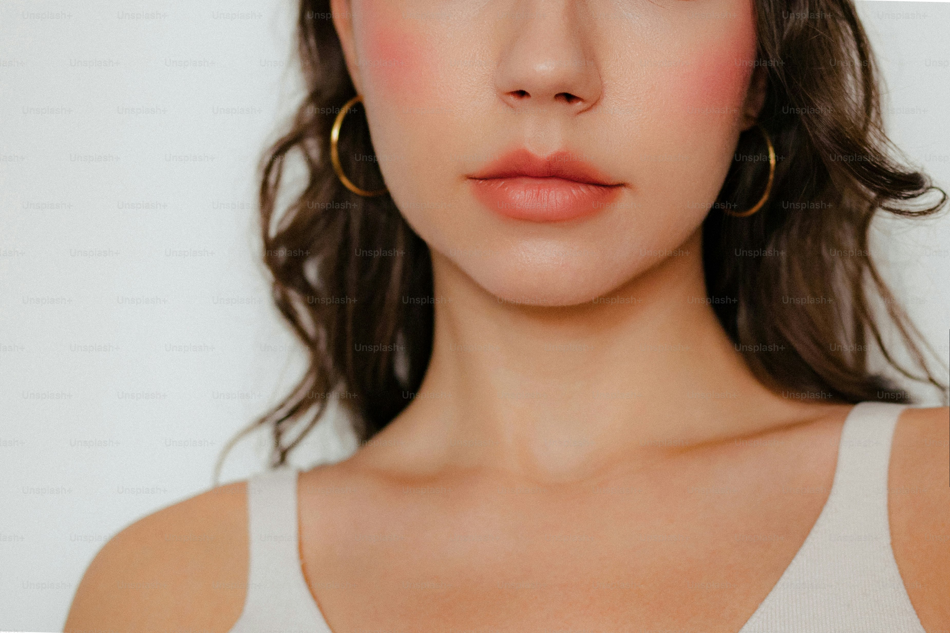 Jeune femme avec des boucles d’oreilles en cerceau et des joues roses