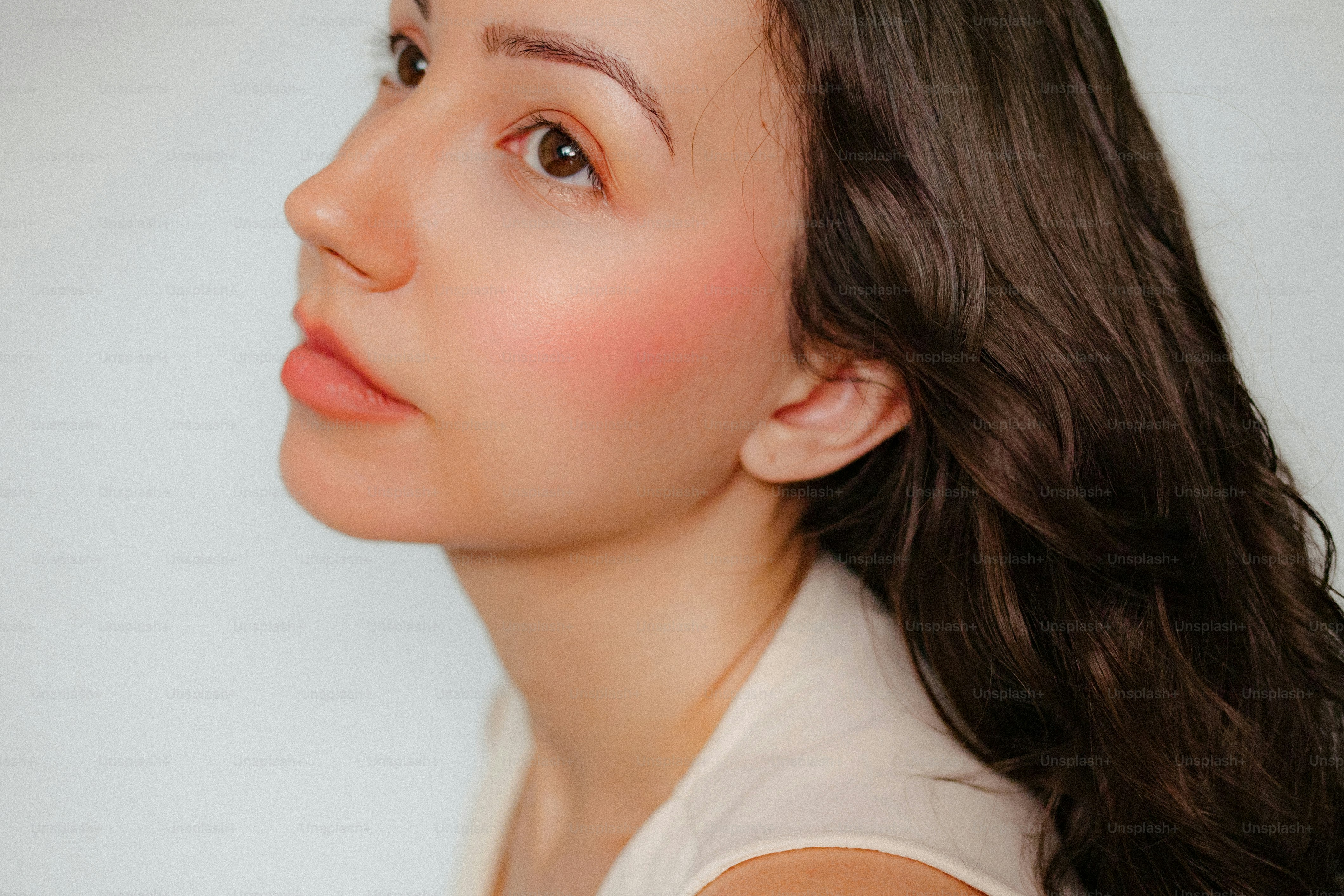 Profil d’une jeune femme aux cheveux foncés et aux rougies.