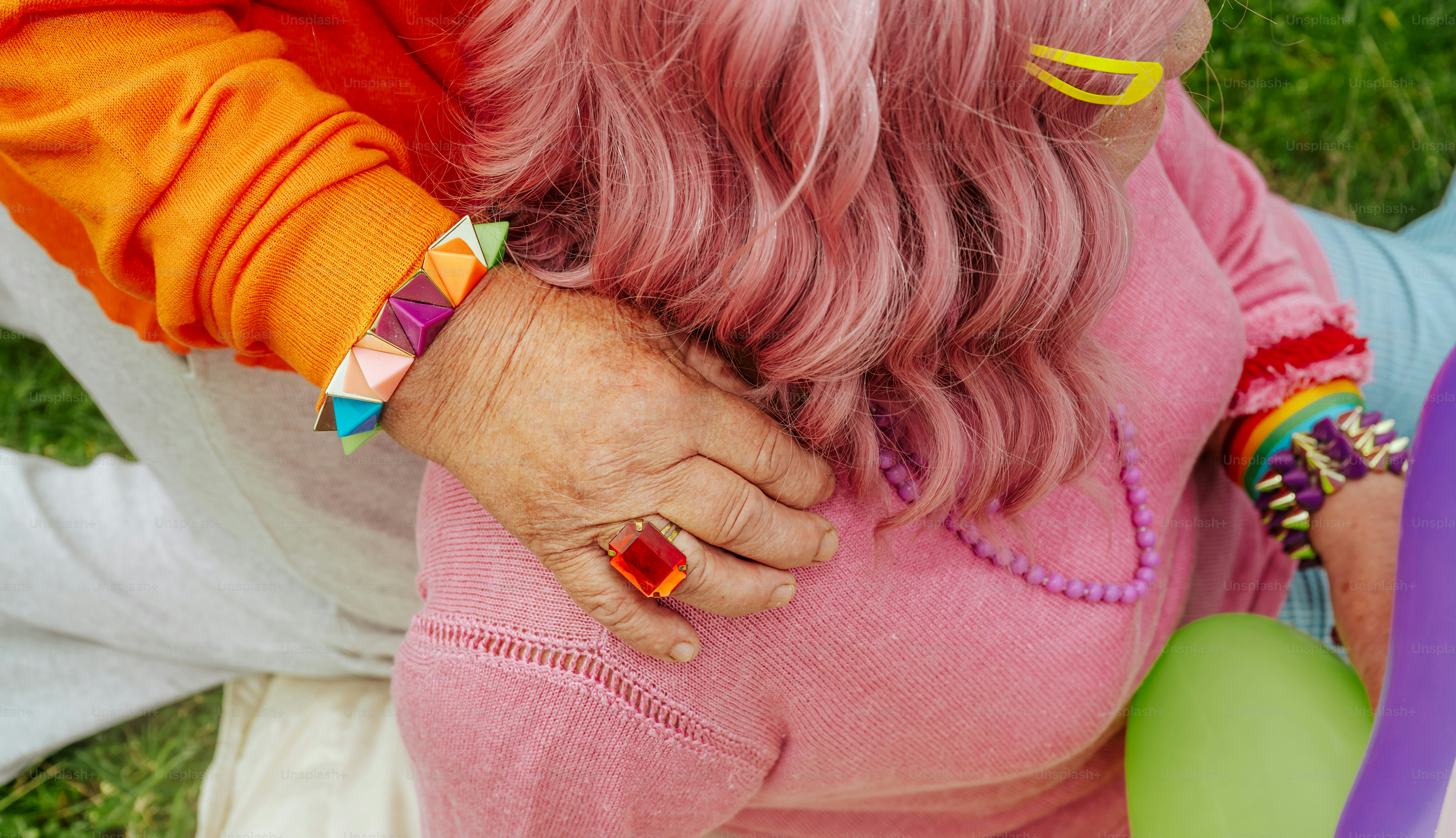 Close-up orang-orang dengan pakaian warna-warni dengan rambut merah muda