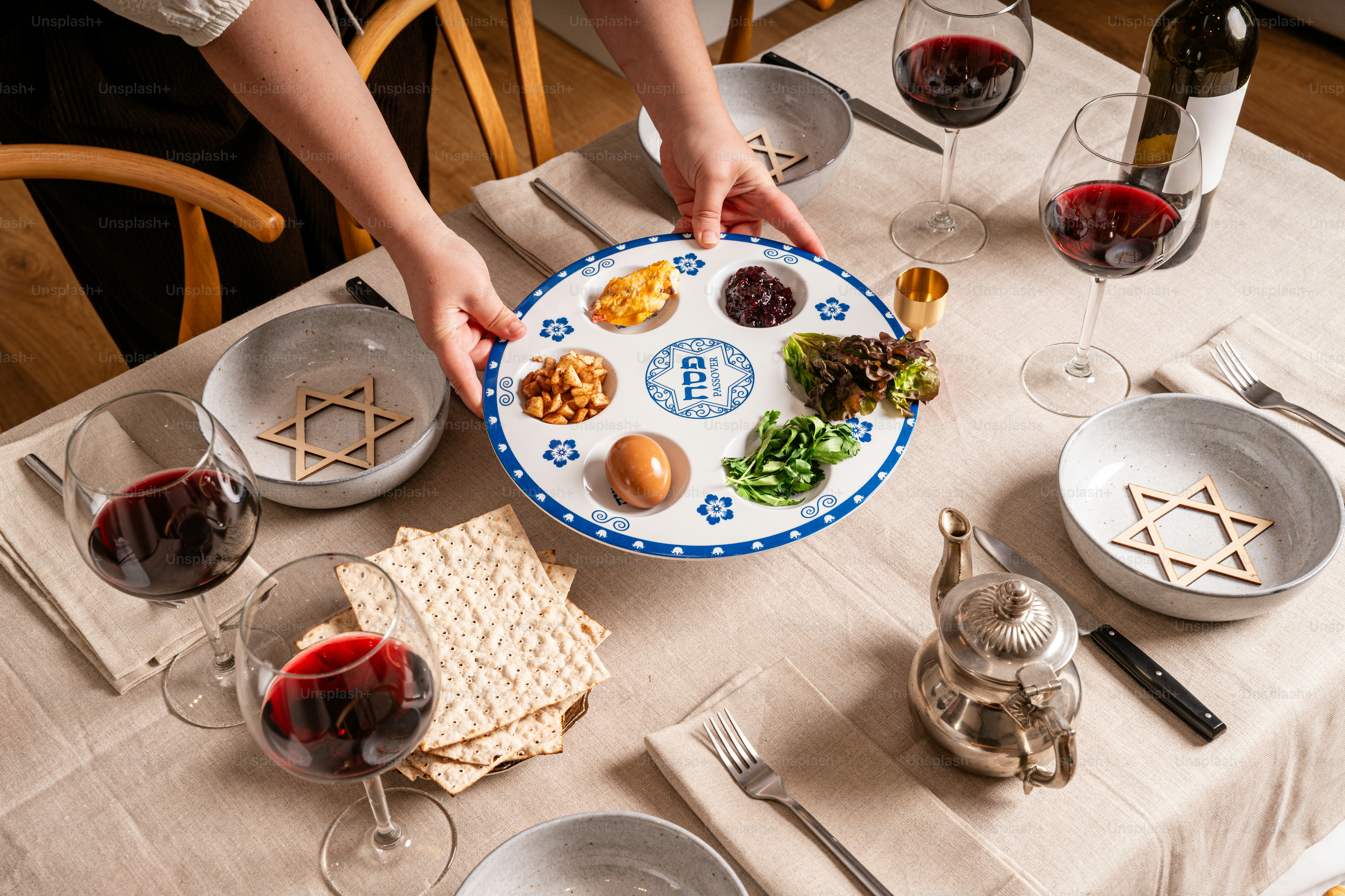 Ein Sederteller mit Matzah und Wein auf einem Tisch