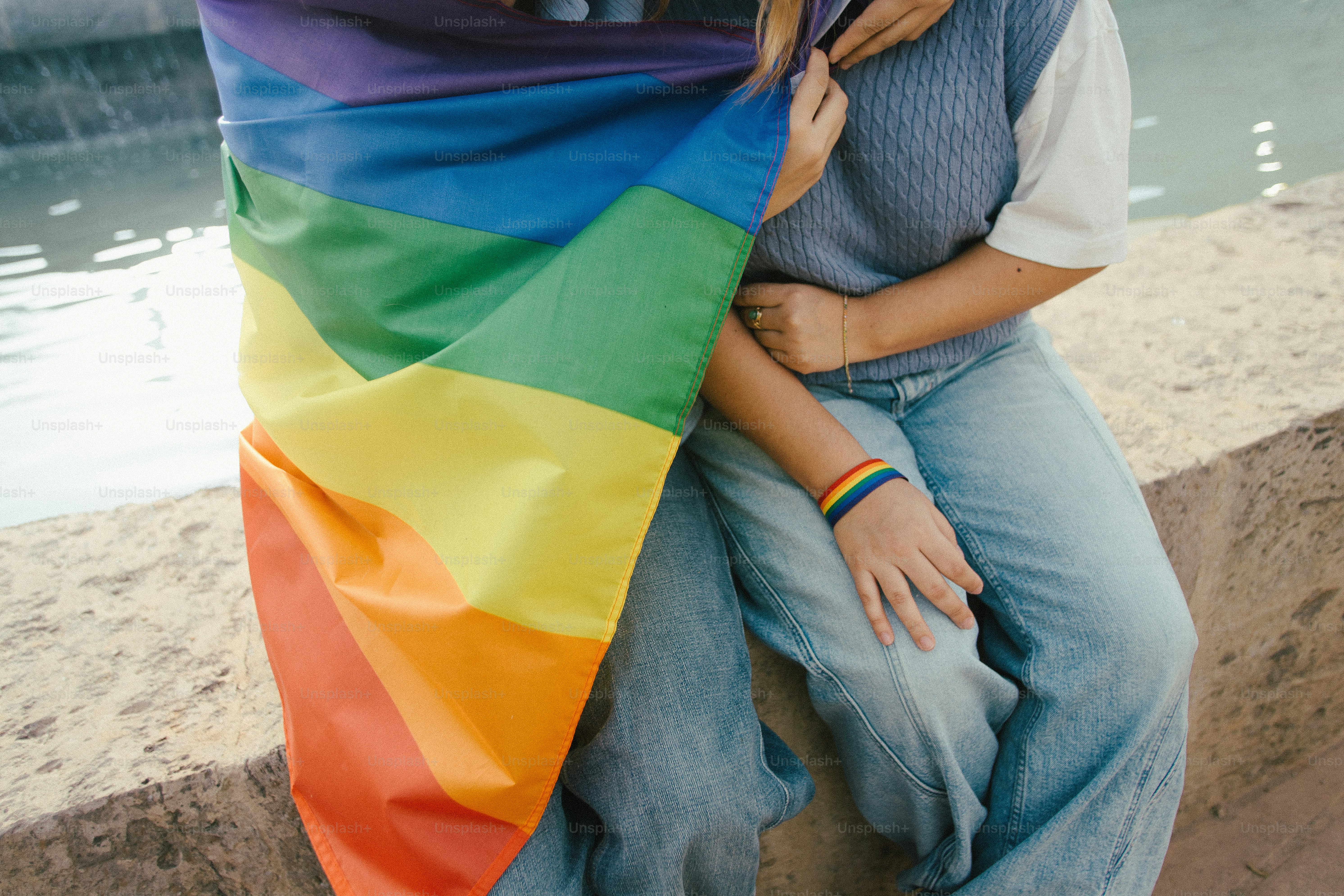 Un couple enveloppé dans un drapeau arc-en-ciel