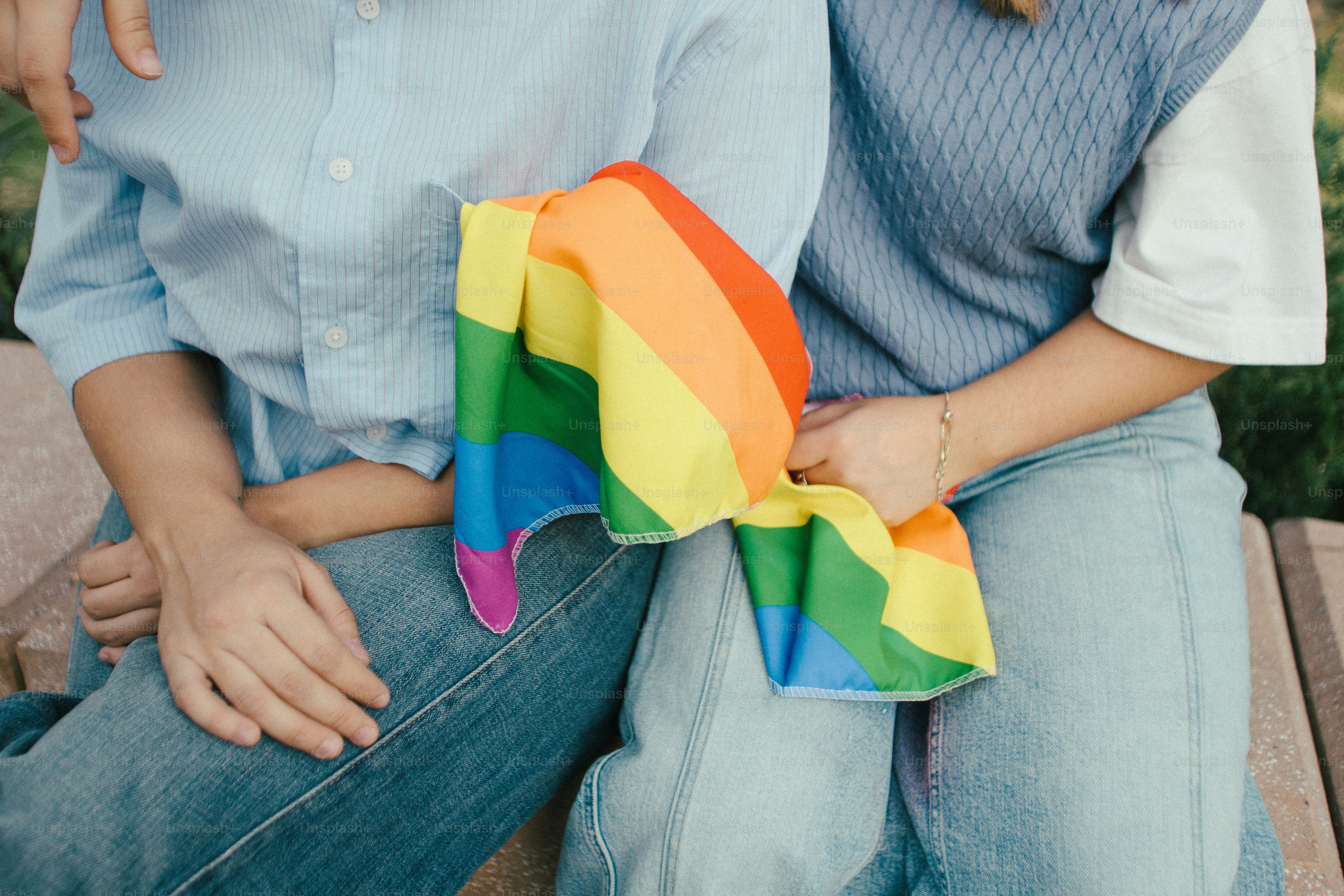 Deux personnes tenant un drapeau arc-en-ciel