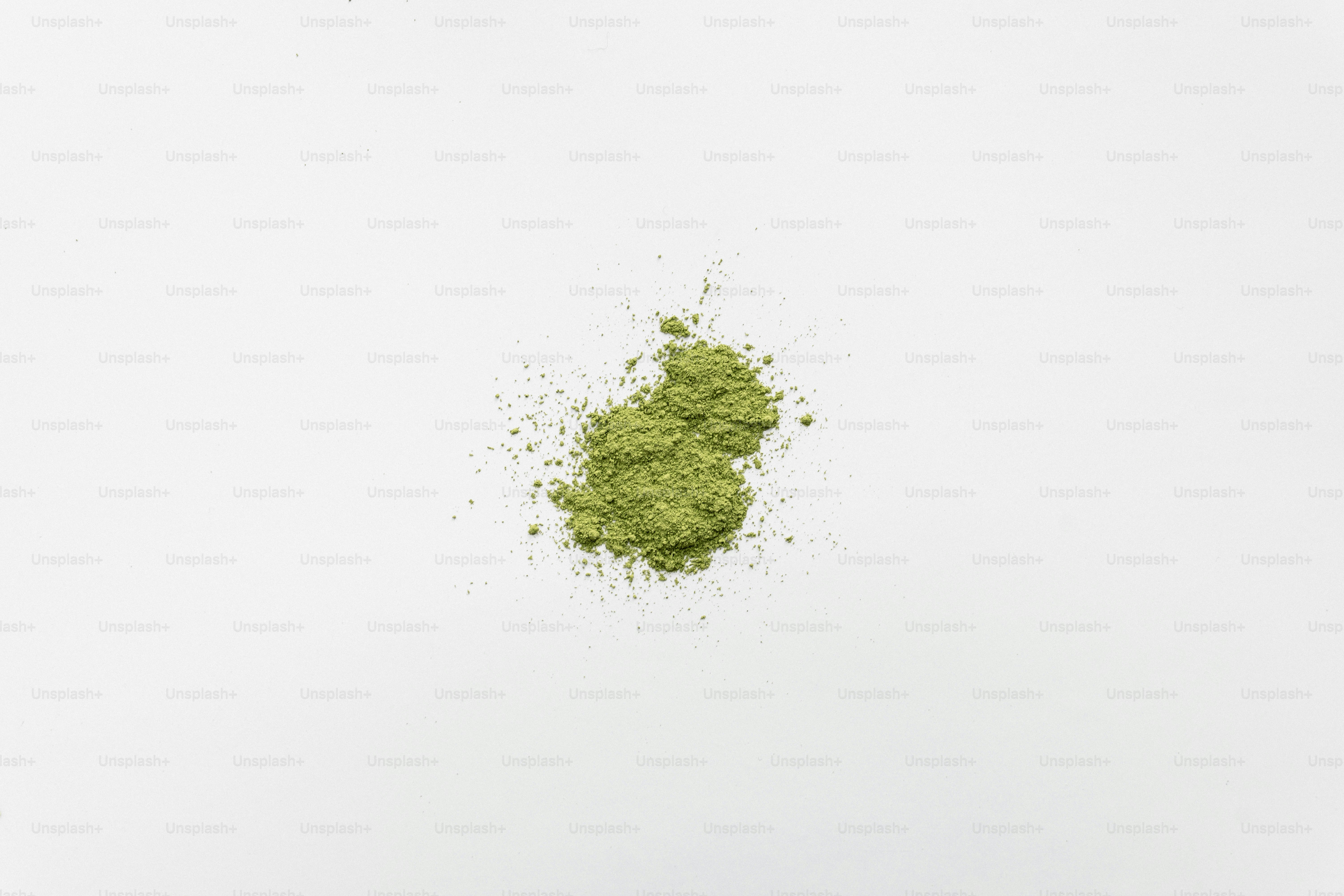 하얀 배경 위에 초록색 가루 작은 더미가 있다