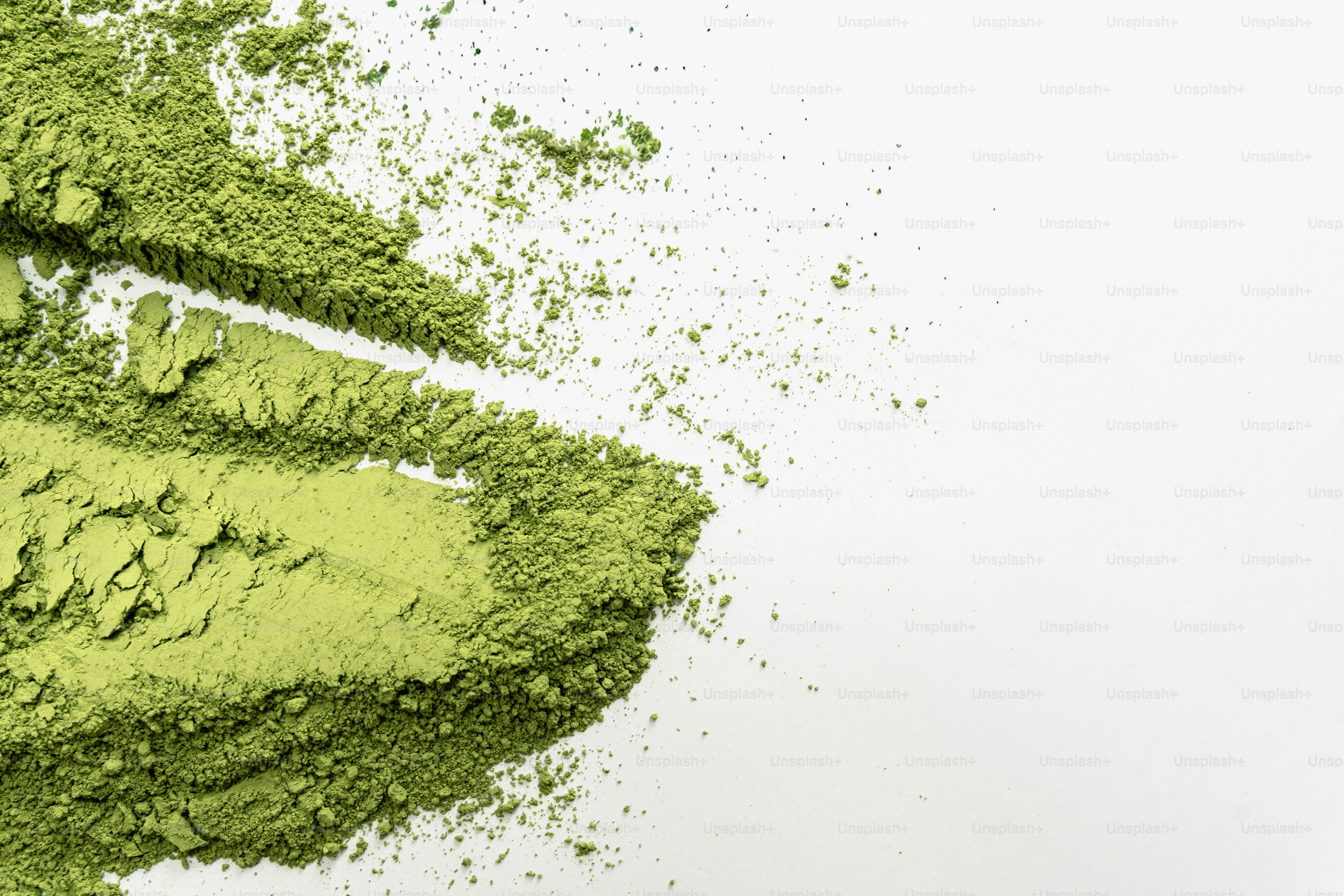 하얀 표면 위에 초록색 말차 가루 더미가 쌓여 있다