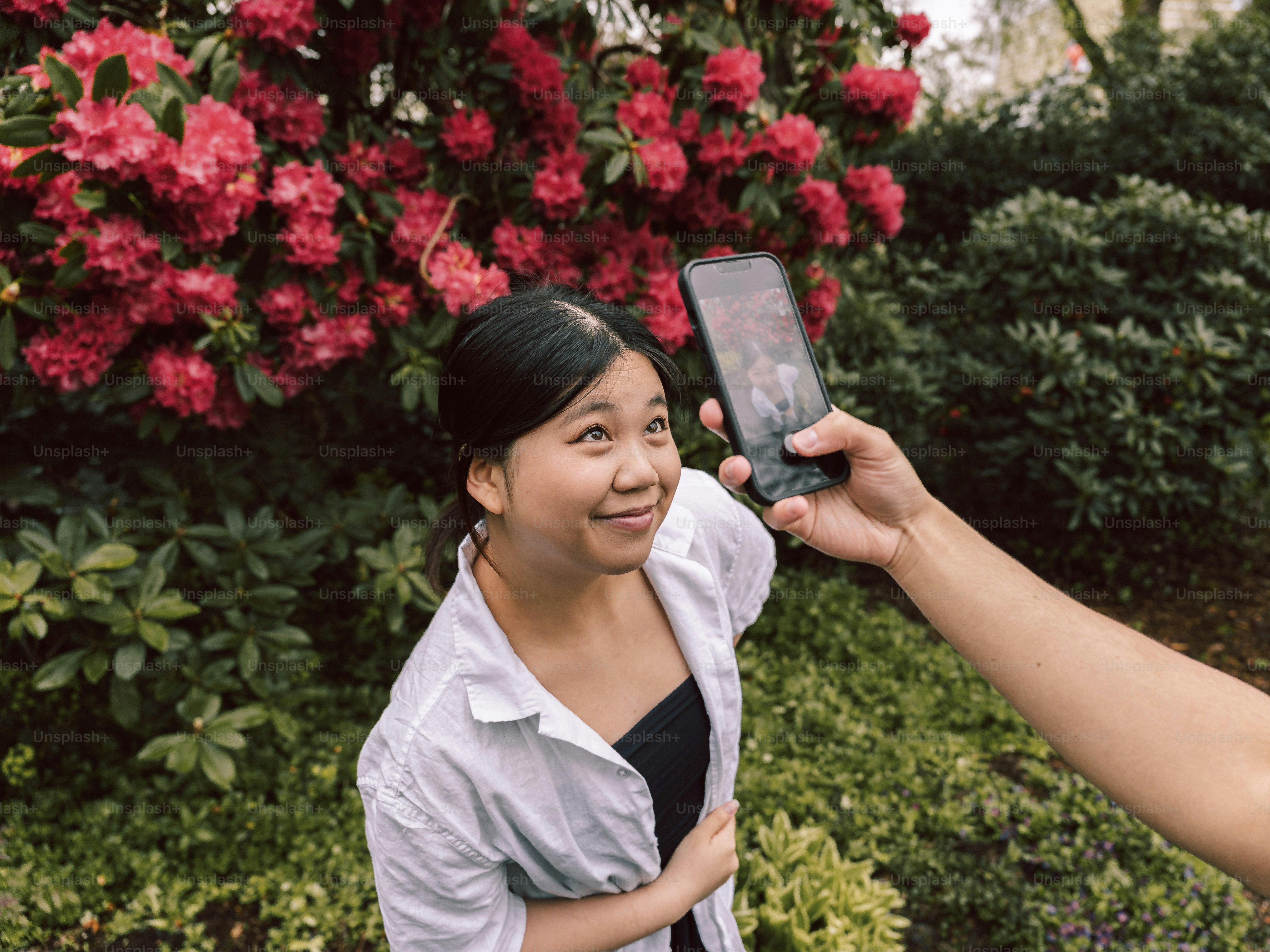 빨간 꽃과 함께 사진을 찍는 여성